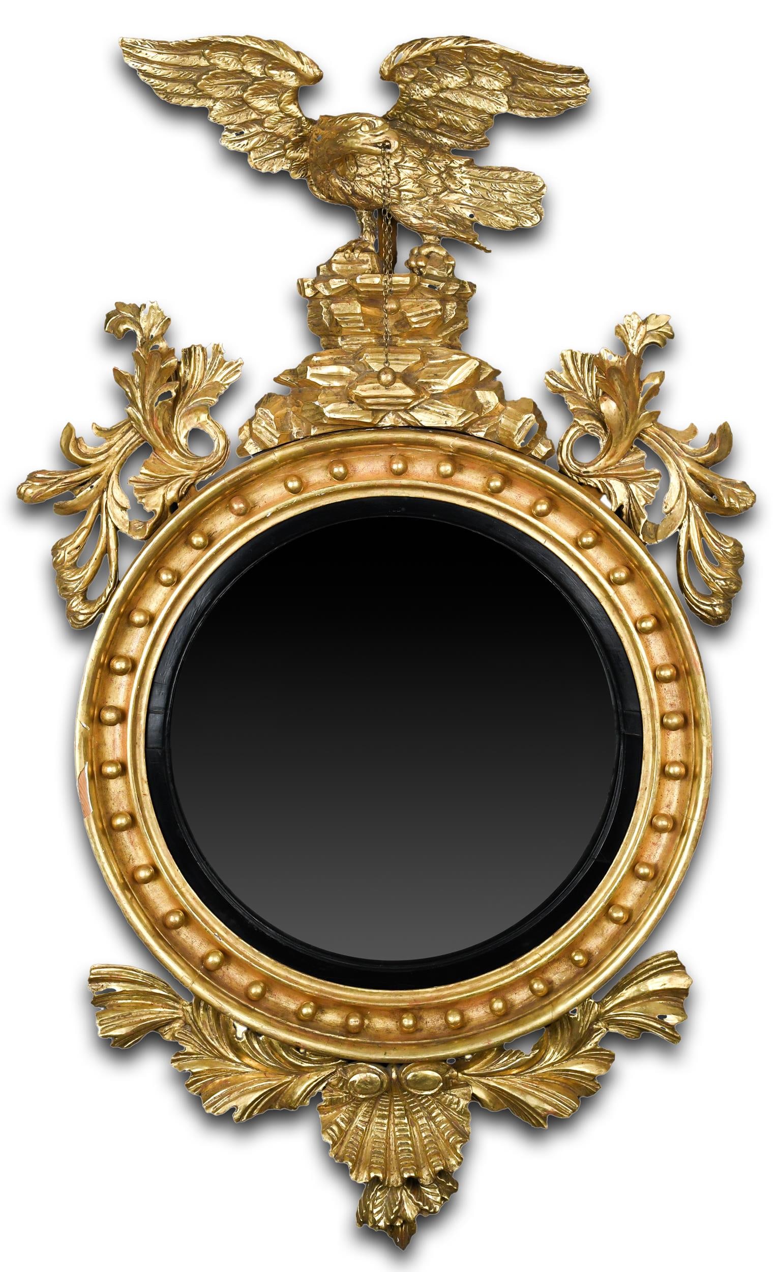 EXCEPTIONAL FEDERAL CARVED AND GILT CONVEX MIRROR.: An exceptional ca. 1825 large Federal carved and gilt convex wall mirror, exhibiting a carved crest with an Eagle perched on rocks, flanked by floral carvings, original convex mirror glass with an ebo