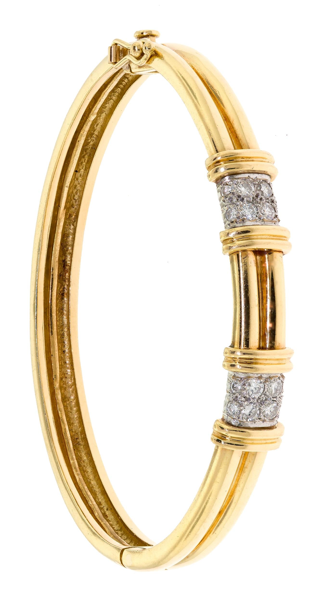 TIFFANY & CO. 18K GOLD DIAMOND BANGLE BRACELET.: A signed Tiffany & Co., 18k yellow gold (stamped), hinged bangle bracelet set with approx. .56 ct. tw., round brilliant cut, natural diamonds of F-G color and VS clarity, approx. 9mm wide, 6