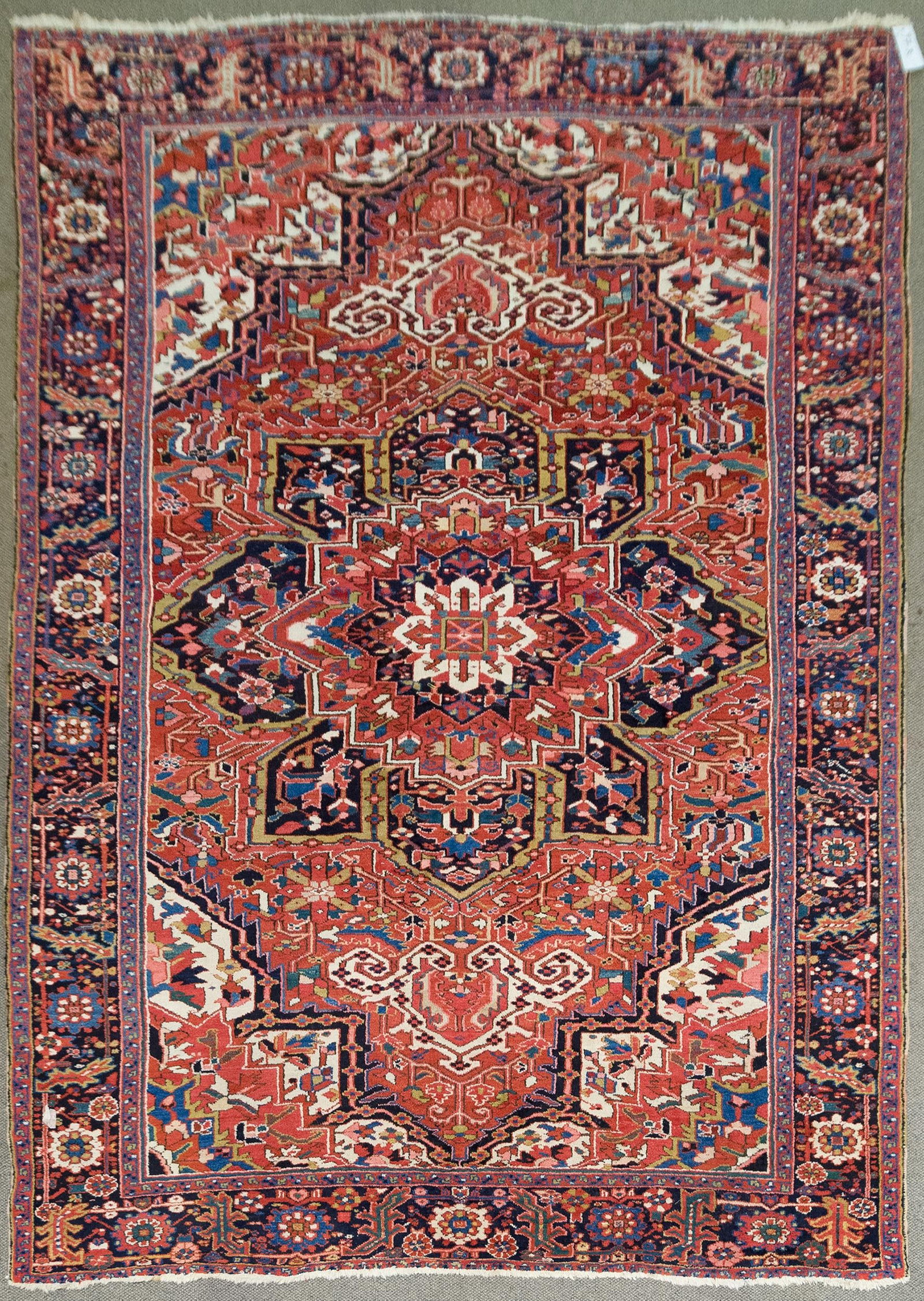 GOOD ANTIQUE HERIZ ORIENTAL RUG.: An antique hand woven Oriental Heriz room size rug, red field, highlighted with ivory, blue, and green. 8'7” x 12’1.