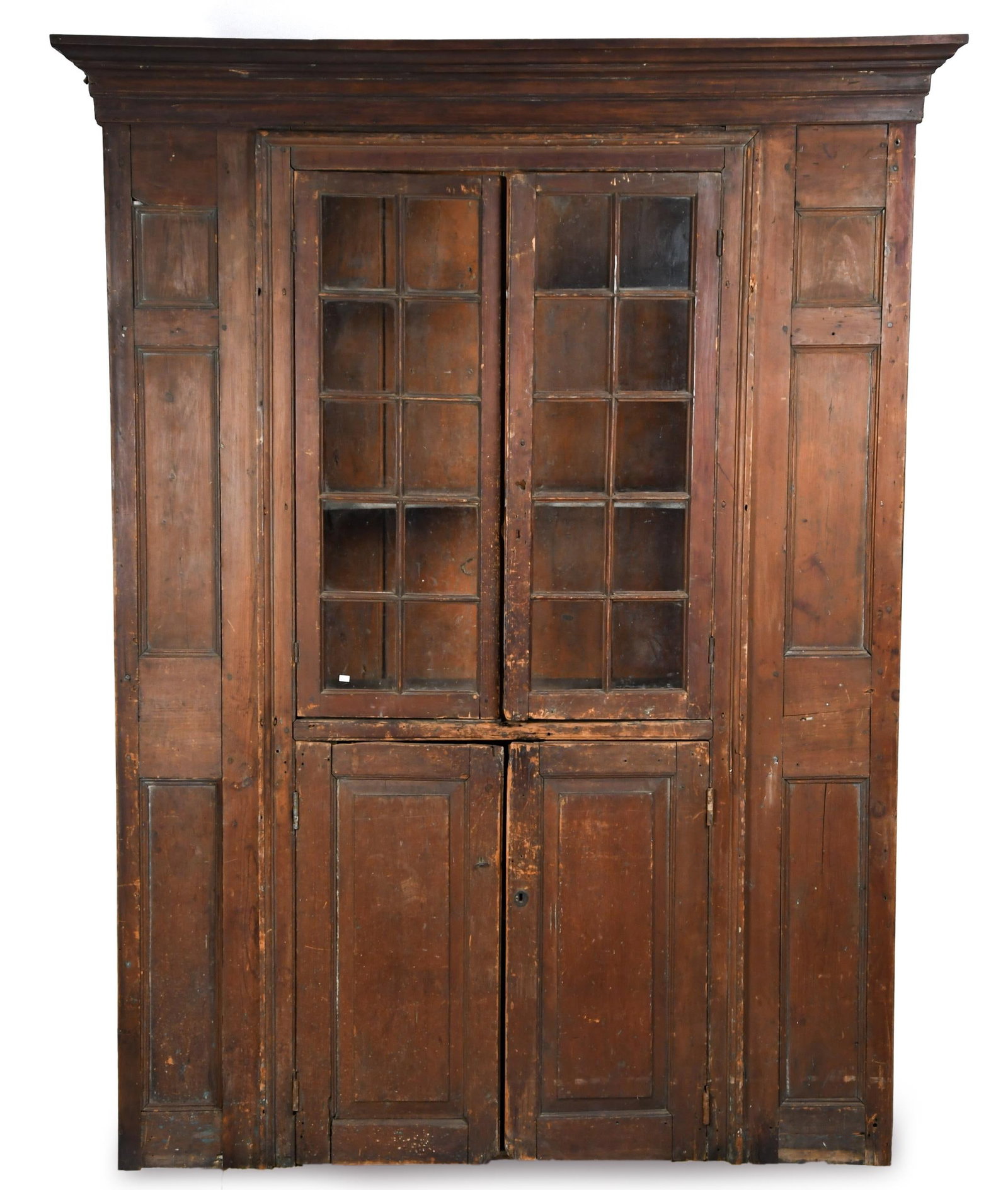 18TH C. MA ARCHITECTURAL CUPBOARD.: A ca. 1770 Quabbin Reservoir area, Massachusetts single part floor standing wall cupboard, having a projecting cornice molding over two ten-light doors, over two raised panel doors, flanked on either 