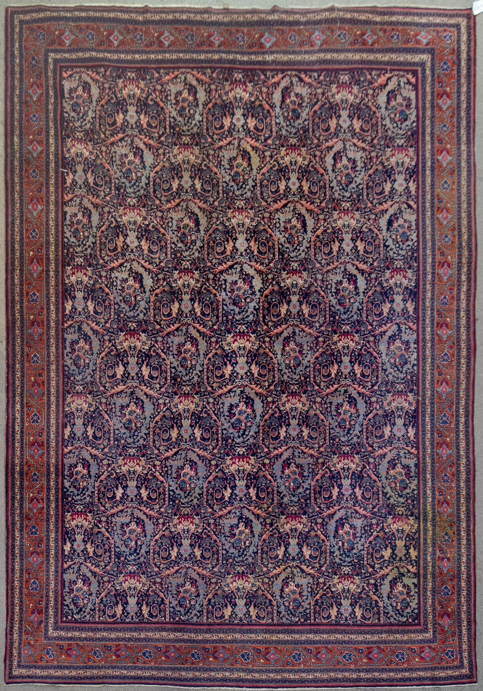 ANTIQUE ORIENTAL ROOM SIZE RUG.: A good hand woven antique Oriental room size rug with dark blue ground, highlighted with red, tan and light blue. 10’10” x 15’6”.