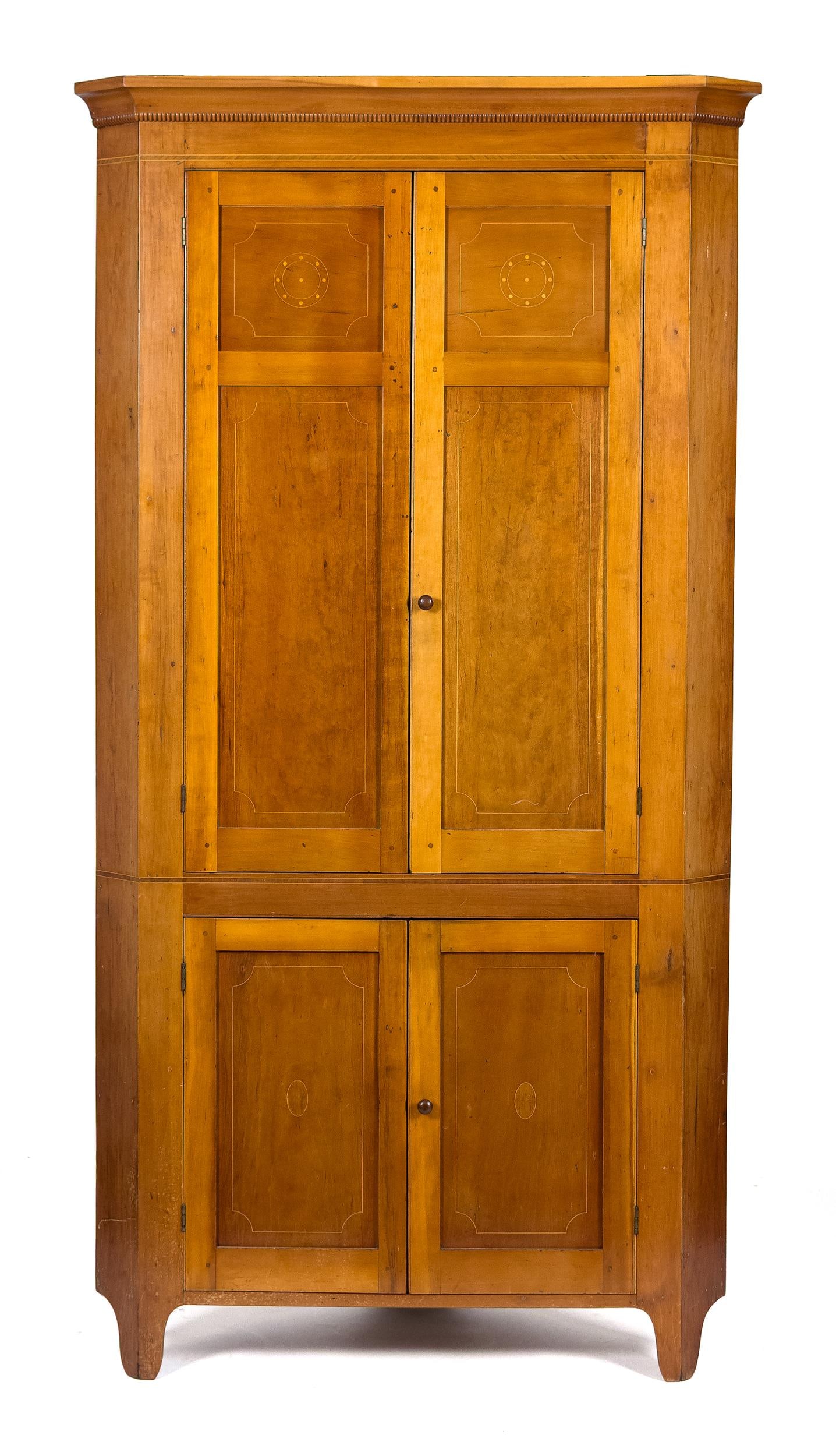 19TH C. AMERICAN FEDERAL CHERRY CORNER CUPBOARD.: A ca. 1820 American cherry one part corner cupboard, with an applied cornice and spool turned moldings, over banded inalid detail, with two paneled doors, over two lower paneled doors, on cutout