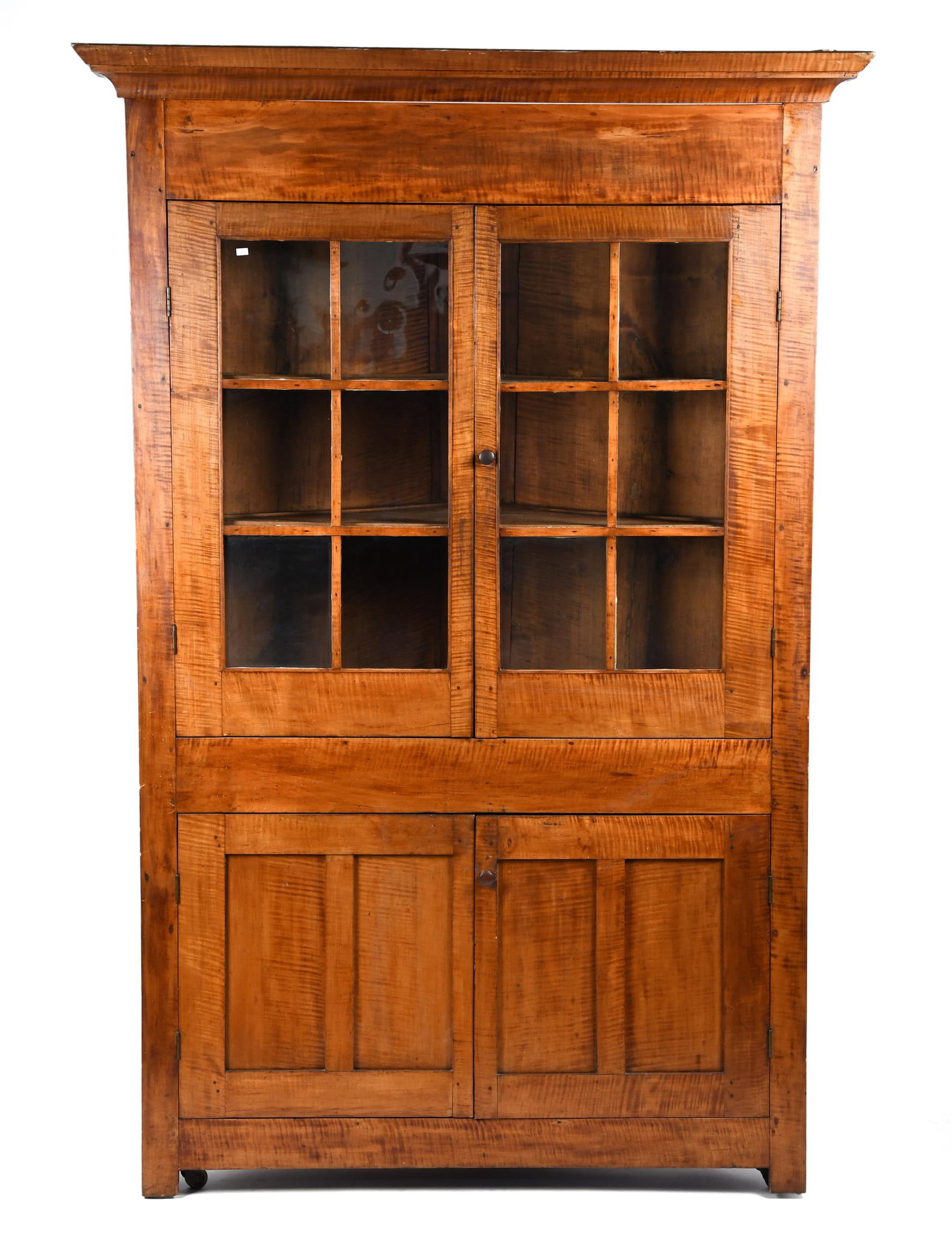 19TH C. AMERICAN TIGER MAPLE CORNER CUPBOARD.: A ca. 1800 American one part tiger maple corner cupboard of unusual proportions. Upper section with cornice molding, two paneled glass doors, interior with two tiger maple fixed shelves, two lower pan