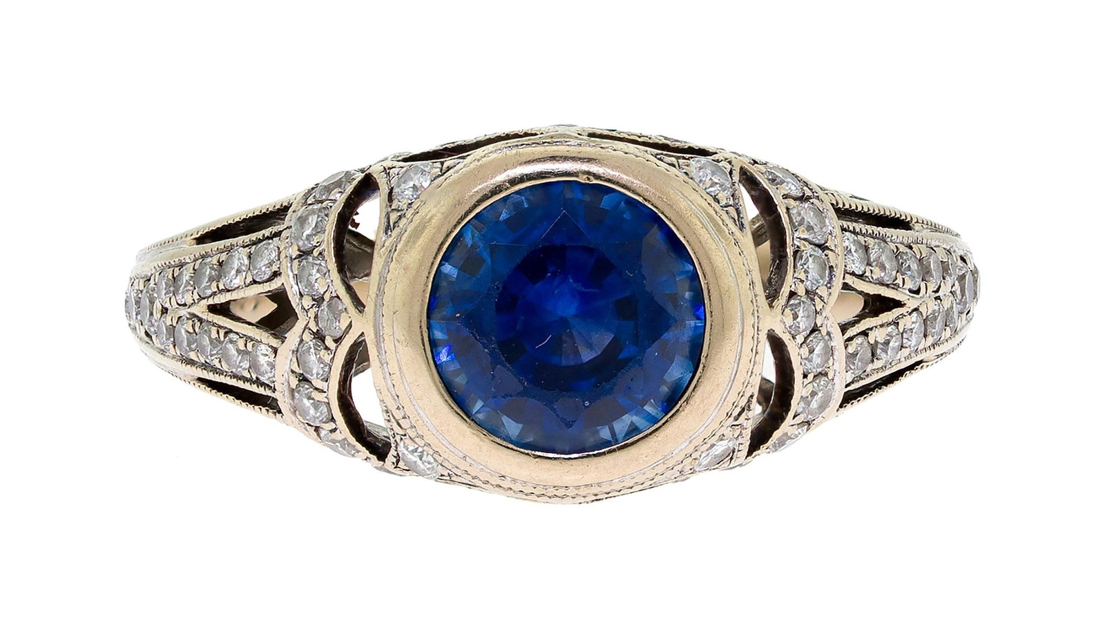 18K GOLD HAND-ENGRAVED BLUE SAPPHIRE & DIAMOND RING.: An 18k white gold (stamped), hand-engraved ring set with an approx. 1.0 ct., faceted round, medium dark, blue sapphire and approx. .28 ct. tw. round brilliant cut, natural diamonds of G-H color and