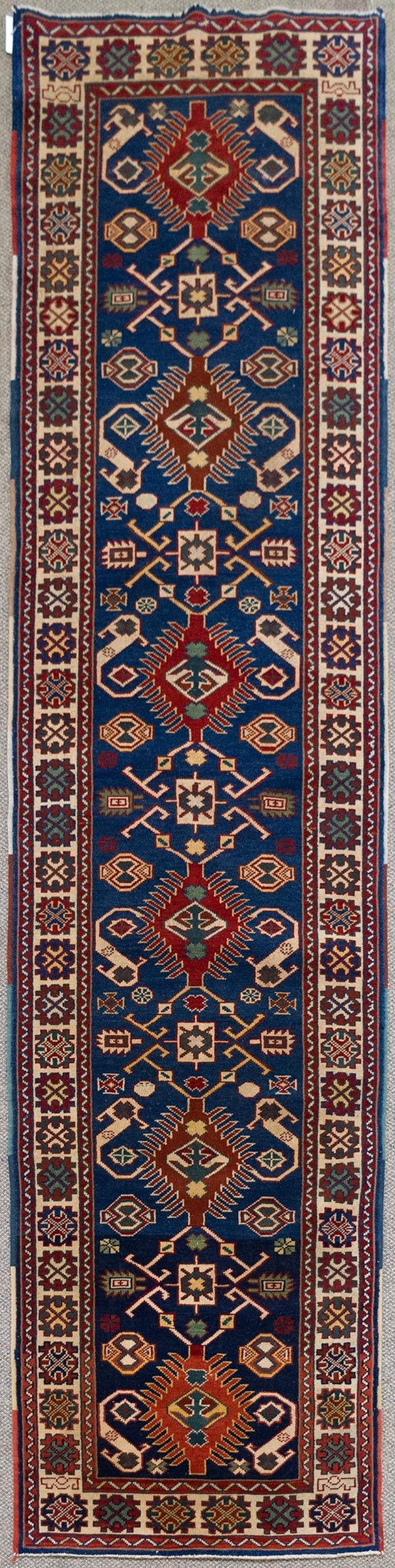 VINTAGE ORIENTAL RUNNER RUG.: A vintage hand woven Oriental Turkish design runner rug with cobalt blue ground, highlighted with geometric motifs.2' 7” x 10’2”.