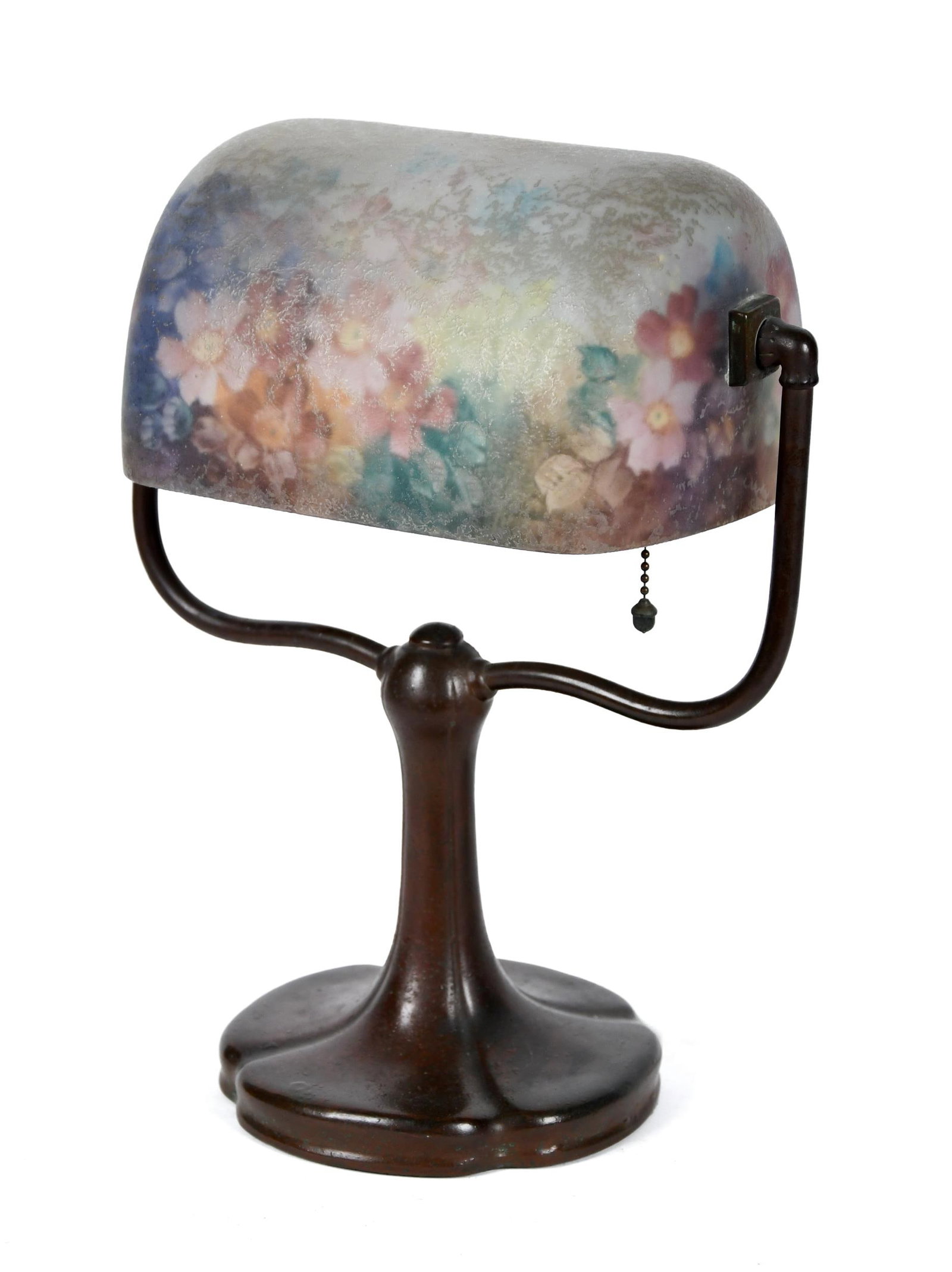 ANTIQUE HANDEL DESK LAMP, 6760.: An antique Handel lamp with large loaf style shade, reverse painted with pink flowers on a blue and green background, signed on interior rim, ’Handel 696’. On a typical desk lamp base