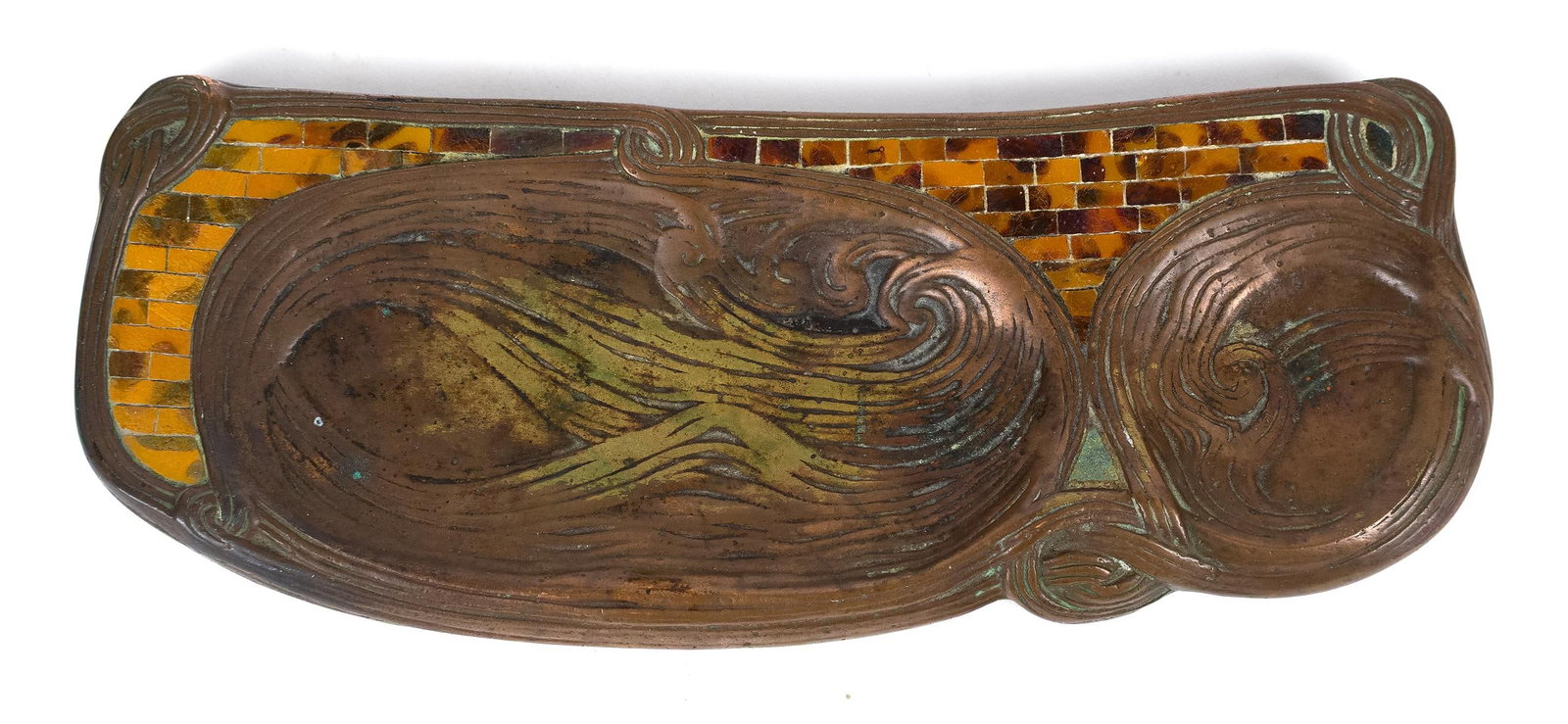ATTRIBUTED TIFFANY STUDIOS BRONZE PEN TRAY.: Early 20th C. unsigned Tiffany Studios bronze and favrile glass pen tray of organic form, with two shallow recesses, inset with small brick-form glass tiles, with rainbow-hued iridescent surfaces.