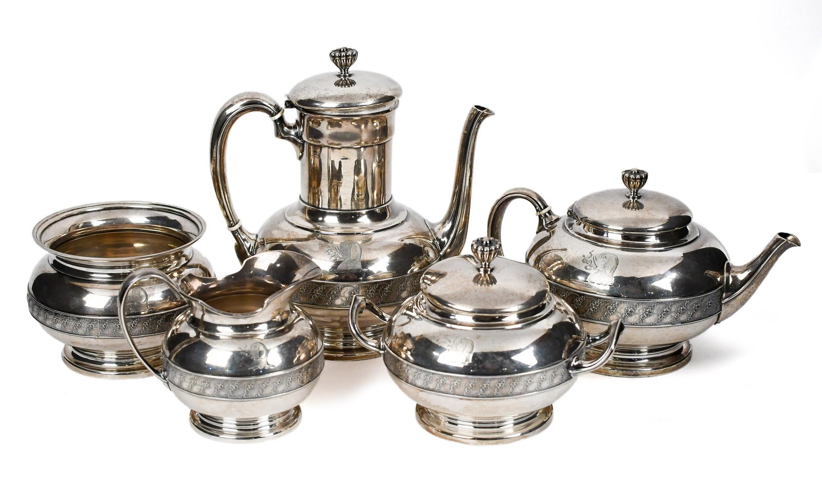 19TH C. TIFFANY & CO. STERLING TEA SERVICE, FIVE PCS.: A ca. 1870 Tiffany & Co sterling silver five piece coffee and tea service, designed by Edward C. Moore, bearing his M monogram. Features a band of swirling florals, and includes monogram of an elephan