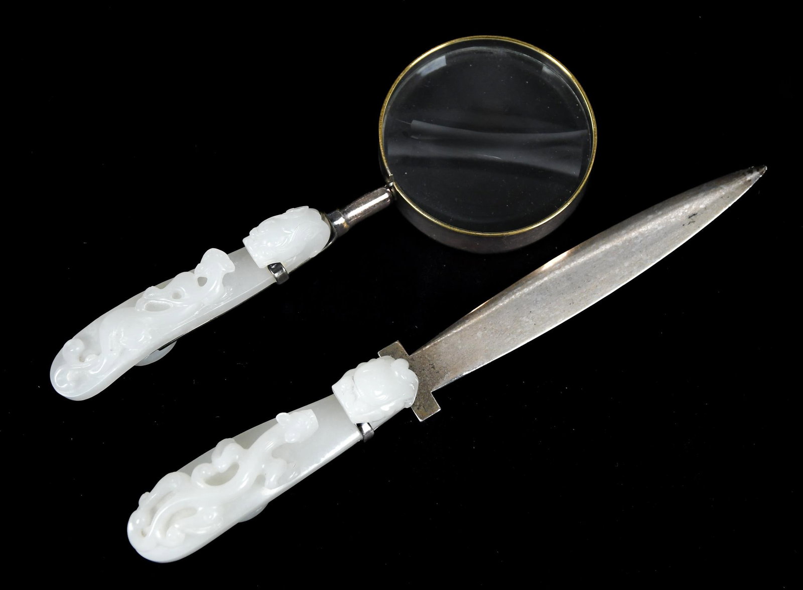 TWO ANTIQUE CHINESE JADE BELT HOOKS.: Two 19th C. Chinese carved white jade belt hooks, mounted as a magnifying glass and letter opener. 3.75”L overall 7” and 8.5” long.