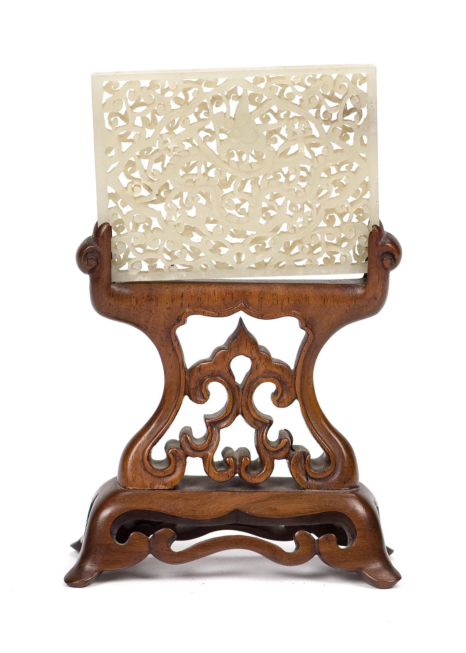 FINE ANTIQUE RETICULATED CHINESE JADE DRAGON PLAQUE.: A very well carved antique reticulated Chinese jade dragon medallion with conforming carved wood stand. Plaque 2.5”H x 3”W, Overall on stand 5.5”H. Provenance: private CT collection.
