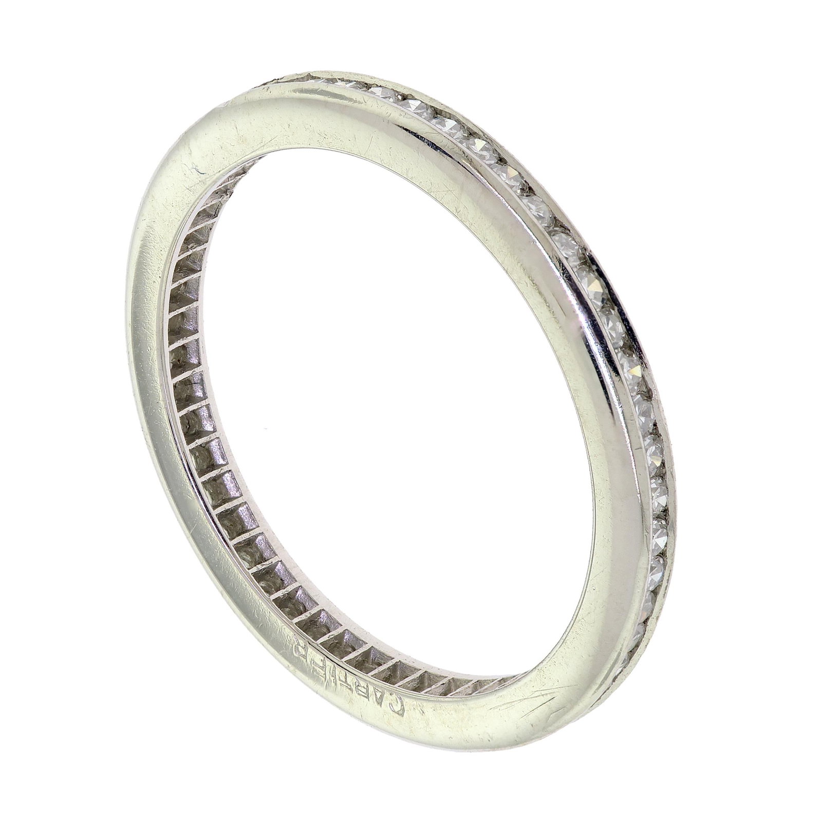 SIGNED CARTIER PLATINUM DIAMOND ETERNITY BAND.: A vintage, signed, Cartier, platinum (tested), channel set, eternity band set with approx. .25 ct. tw., single cut round, natural diamonds of F-G color and VS clarity. Ring size 6 3/4, 3.0 grams.