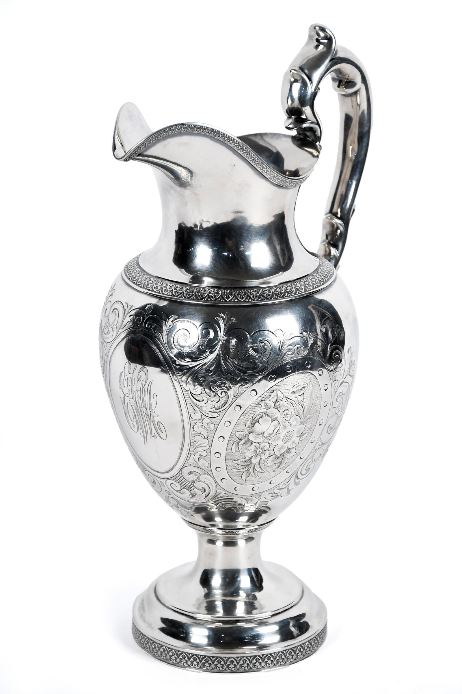 FINE 19TH C. AMERICAN COIN SILVER PITCHER.: A ca. 1830 American coin silver pitcher with engraved/chased decorations and elaborate monogram in central cartouche. Marked on bottoms, ‘Ball Tompkins & Black E&C Suggesters to Marquand & Co