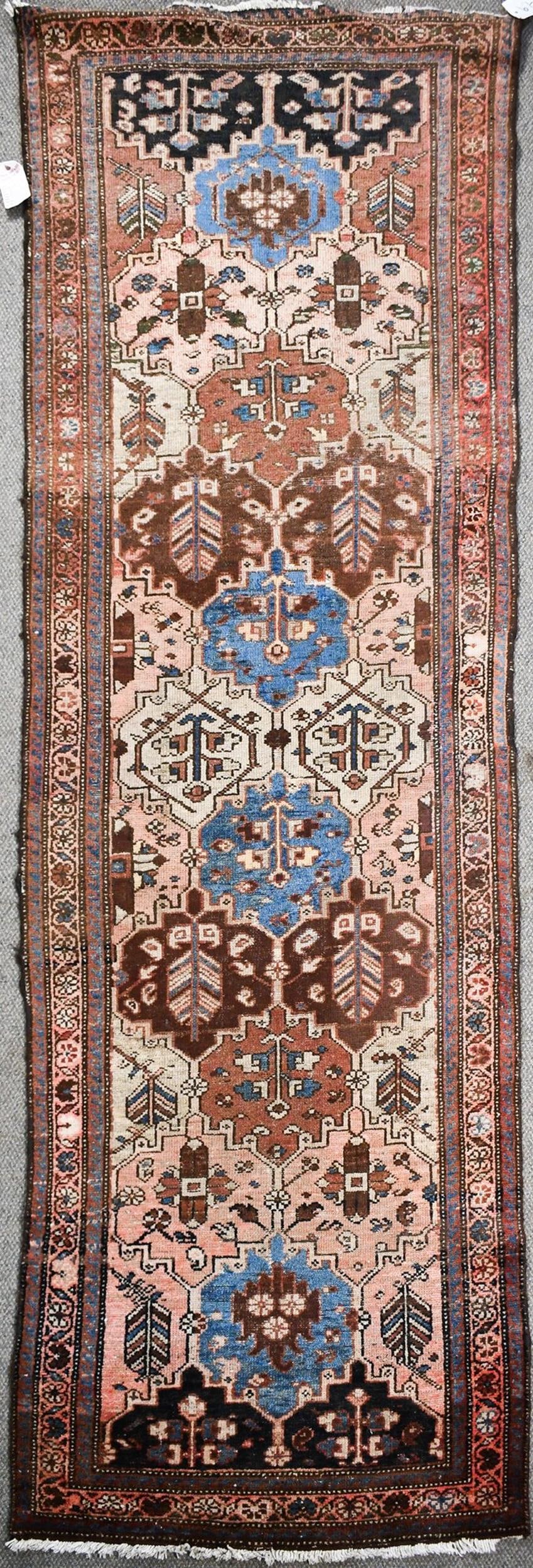 ANTIQUE ORIENTAL RUNNER.: A 1920s Oriental hall runner, rust and ivory field with six medallions.3'3” x 9’.