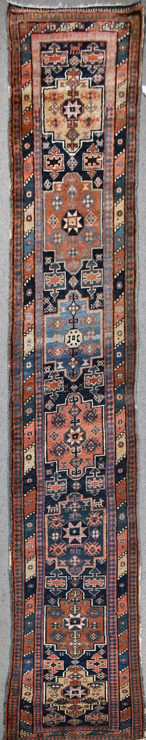 ANTIQUE ORIENTAL HALL RUNNER.: An antique hand woven Oriental hall runner rug with a multi-color geometric field.3’5” x 14’9”.