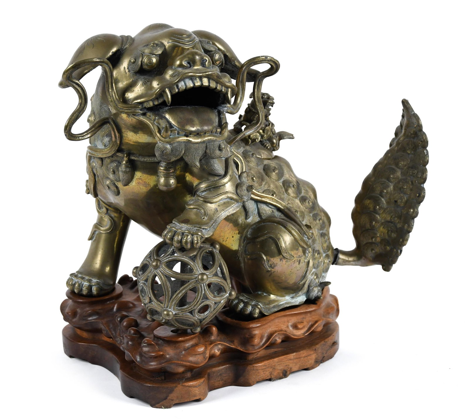 ANTIQUE BRONZE FOO LION WITH STAND.: A heavy and large scale bronze foo lion with removable tail section and hollow body with a removable lion formed finial, on a separate carved wood stand. 15”H x 15”W.