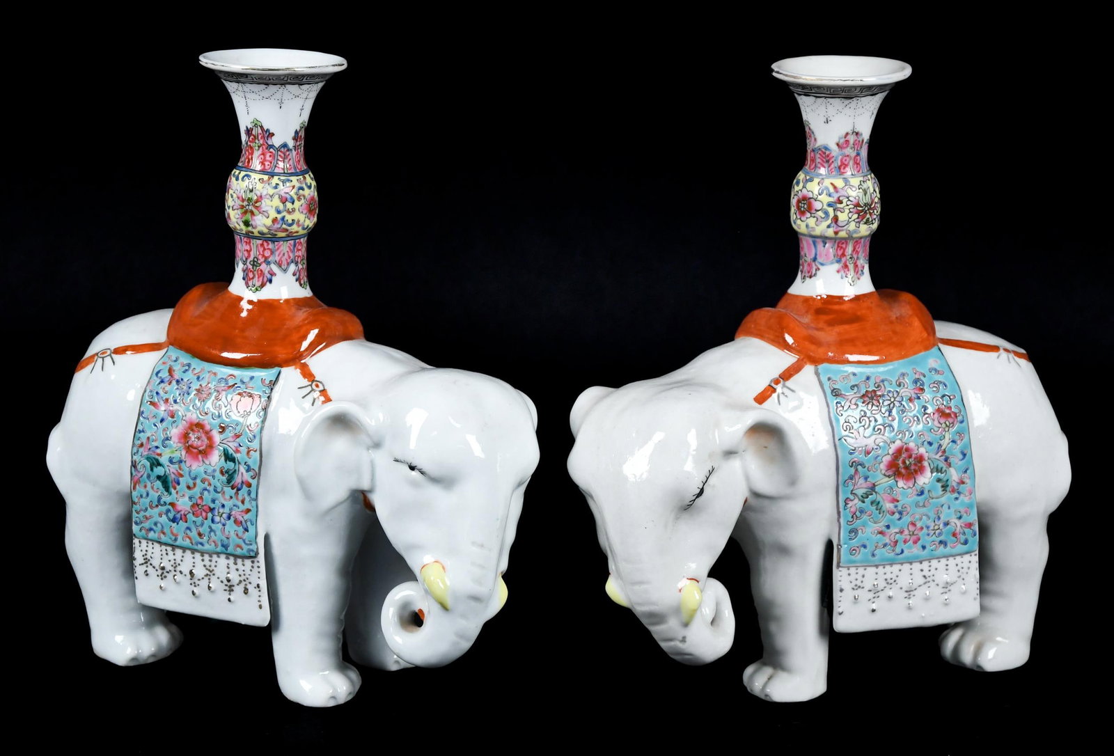 ANTIQUE CHINESE EXPORT ELEPHANT CANDLESTICKS.: A pair of antique Chinese Export porcelain elephant form candlesticks with polychrome famile rose decoration. 10”H x 10”W.