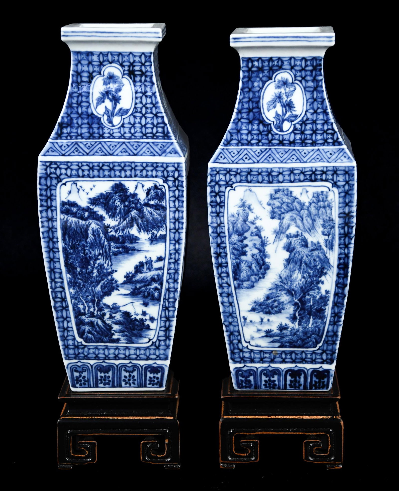 PAIR OF CHINESE BLUE AND WHITE VASES.: A pair of signed vintage Chinese blue and white porcelain vases, each with detailed landscape decoration on tapering, square form bodies. 9”H. Each with a separate wood base.