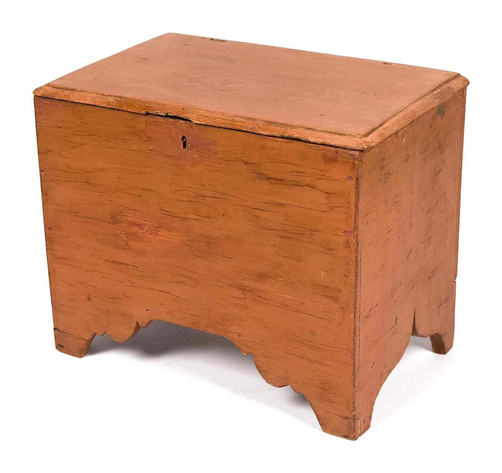 SMALL ANTIQUE SALMON PAINTED BOX.: A ca. 1800 New England pine salmon painted small lift top box with snipe hinges, early T and rose heads, cut out feet with a wonderful scalloped apron, 15”H x 18”W x 11.5”D.