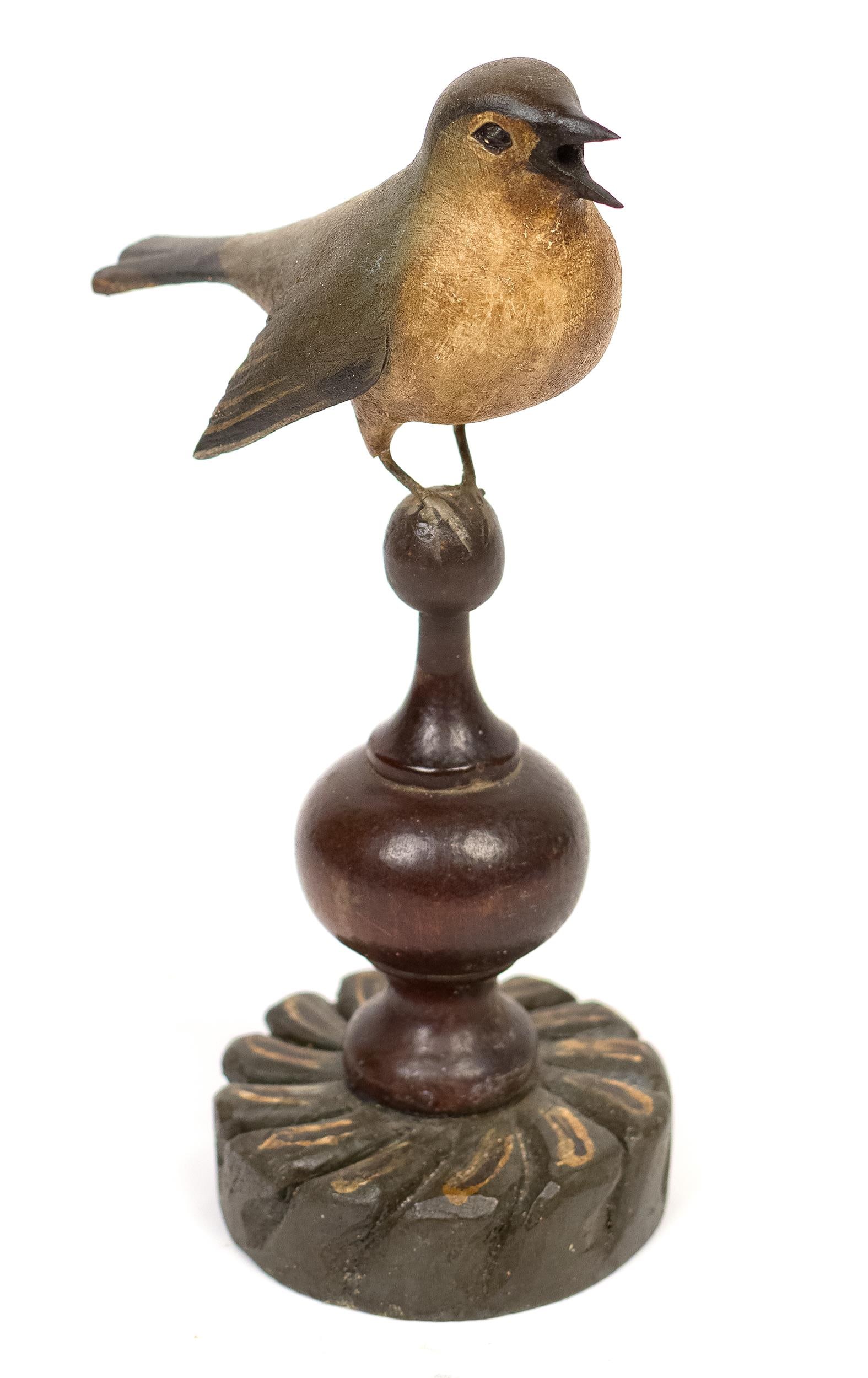FRANK FINNEY CARVED AND PAINTED BIRD ON FINIAL.: A 20th C. carved and painted song bird on a pedestal signed on the bottom, F. Finney, 9.25”H. Provenance: the estate of Donald Roach Barrington RI.