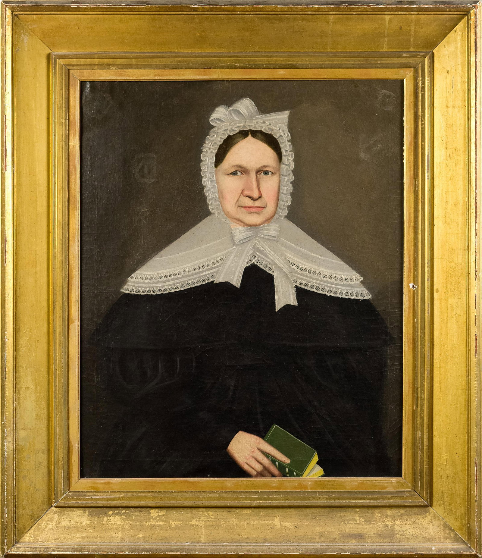 19TH C. NEW ENGLAND PORTRAIT PAINTING, WOMAN W/ BOOK.: A ca. 1840 oil on canvas portrait of a woman in lace bonnet and black dress, and holding a green book. Attributed to Erastus Salisbury Field. Image 31” x 26”, Frame 42” x 36”. 