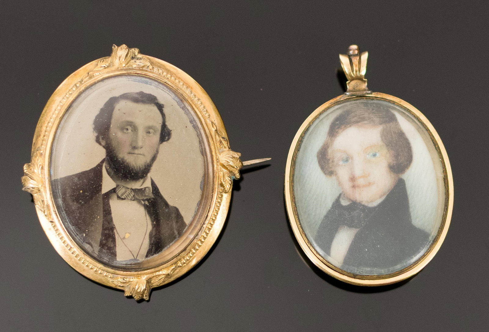 TWO VICTORIAN 10K-14K GOLD FRAMED PORTRAITS.: Two Victorian, 10k-14k yellow gold (tested), framed portraits:pendant w/ hand painted portrait of a young man w/ empty hair locket on reverse, 1 7/8”L, inner frame is gold filled, some scratches