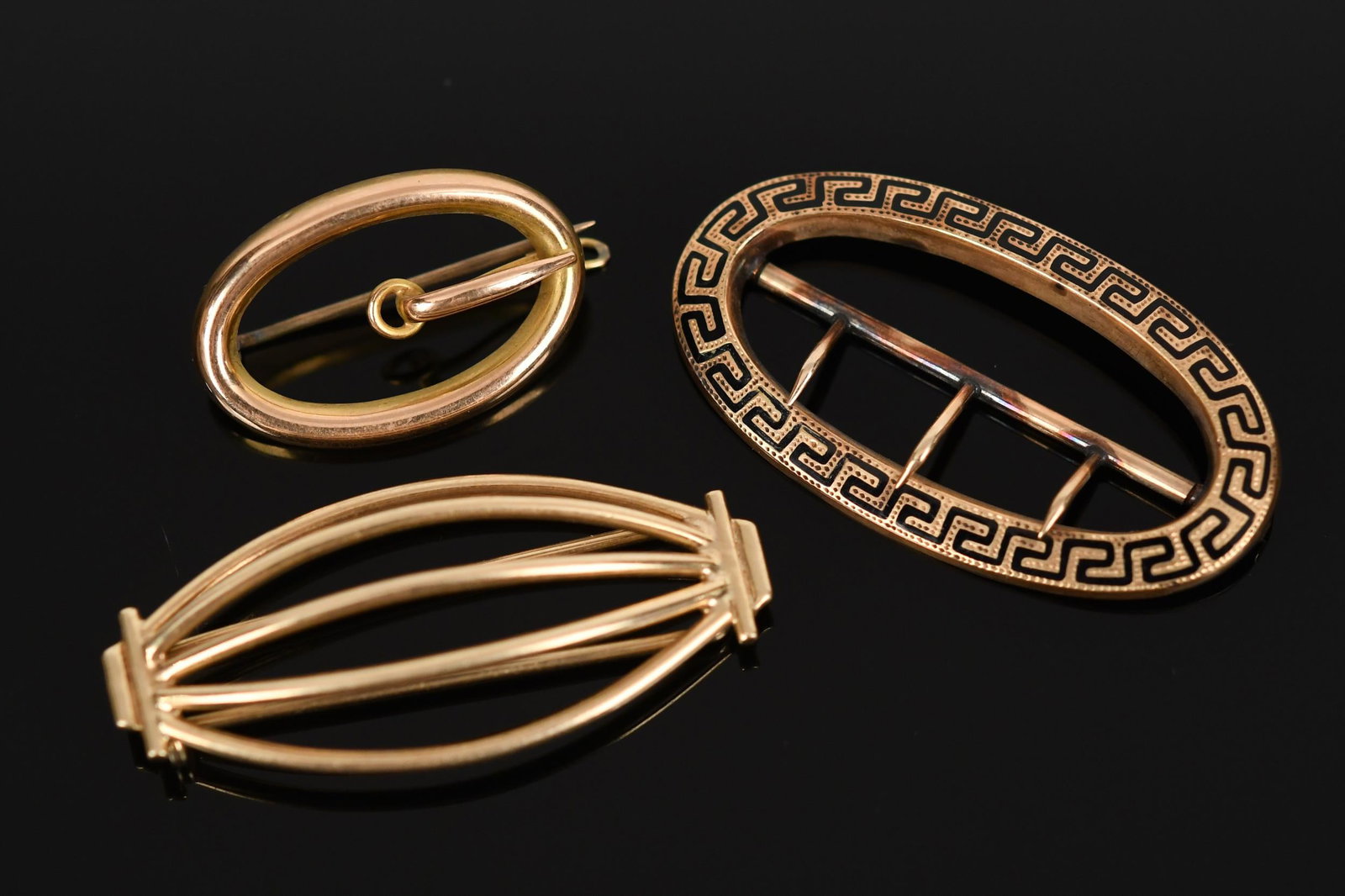 ANTIQUE 14K GOLD PIN, BARRETTE & SASH BUCKLE.: Antique, 14k yellow gold (stamped or tested), black enamel, sash buckle, 1 7/8” long, barrette or hair clip, 1 7/8” long, oval pin with loops, 1 1/8” long, 17.3 grams total weight.