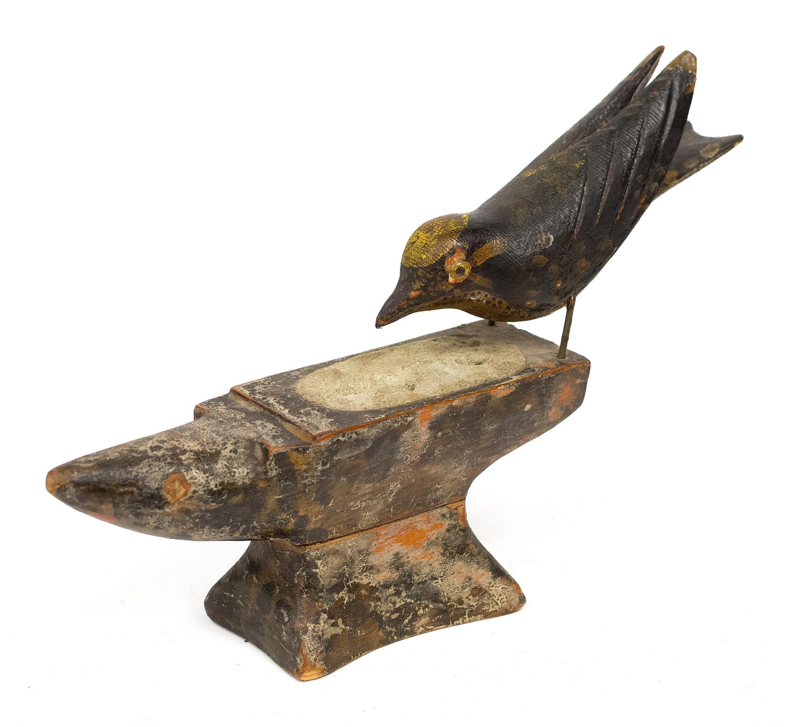 JOSEPH ROMUALD BERNIER CARVED AND PAINTED BIRD.: A ca. 1900 Maine carved and painted pine wood bird with glass eyes on an anvil, attributed to the Maine folk carver Joseph Romuald Bernier. 8.5”H x 13”L. Provenance: the estate of Donald