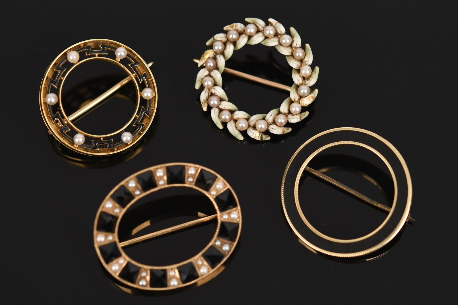 FOUR ANTIQUE 14K GOLD ENAMEL & PEARL CIRCLE PINS.: Four, antique, 14k yellow gold (stamped), black onyx, seed pearls, black enamel and white and green enamel, approx. 7/8” to 1 1/8” dia., 15.8 grams.