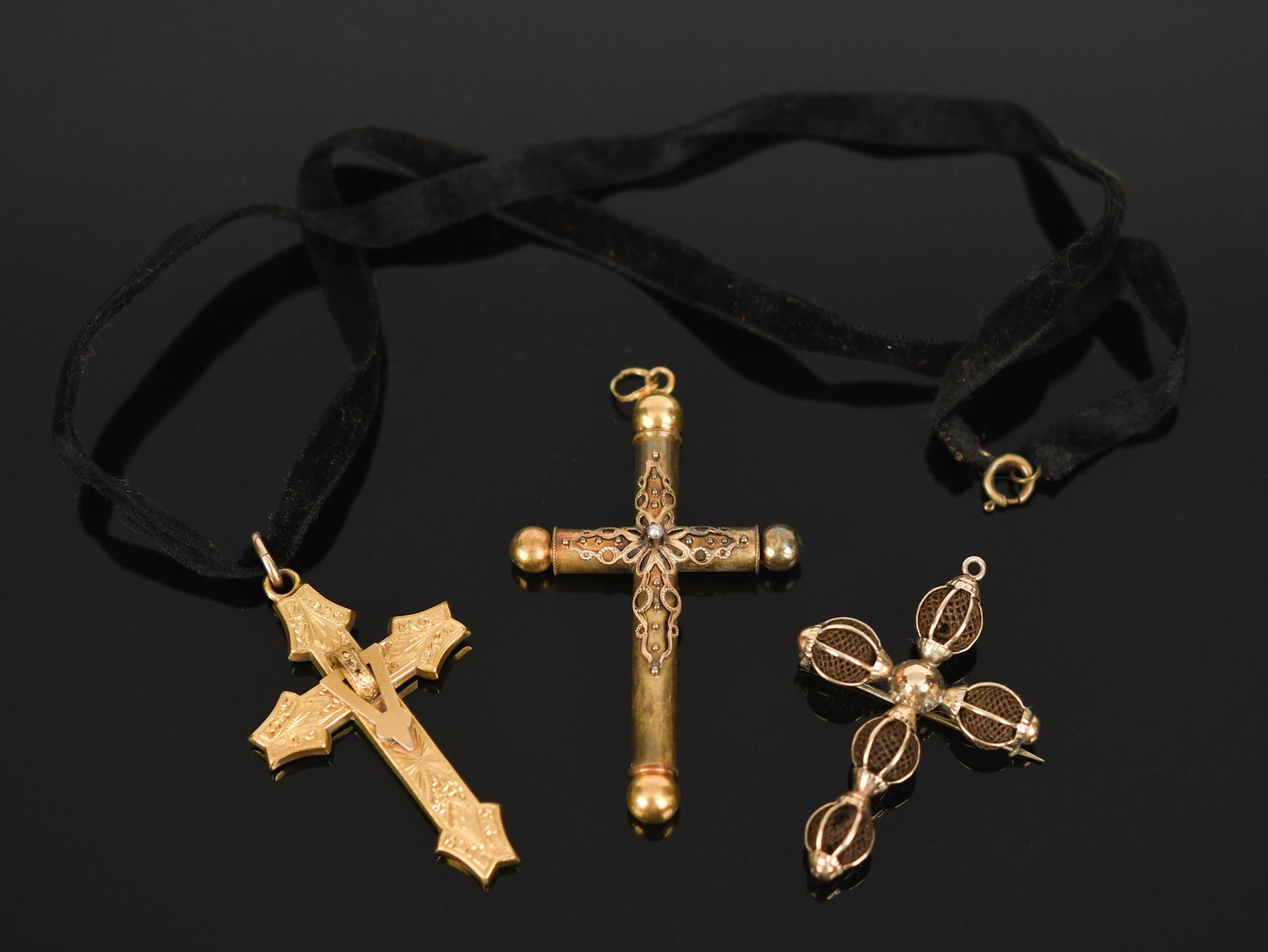 THREE VICTORIAN GOLD & GOLD-FILLED CROSSES.: Three Victorian, yellow gold and gold-filled (all tested), crosses: gold-filled is hand-engraved on black velvet ribbon, 2 3/16” long; 14k hairwork pin (pin catch is broken) with loop at top for