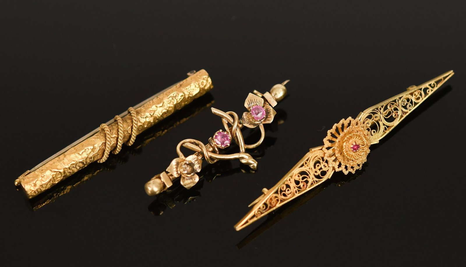 THREE VICTORIAN ANTIQUE GOLD PINS.: Three, Victorian, pins, a 14k yellow gold (tested) bar pin, 2 inches long, pin stem is not gold, a 14k yellow gold (tested), filigree pin with a small ruby, 2 5/8 inches long and a 10k yellow gold