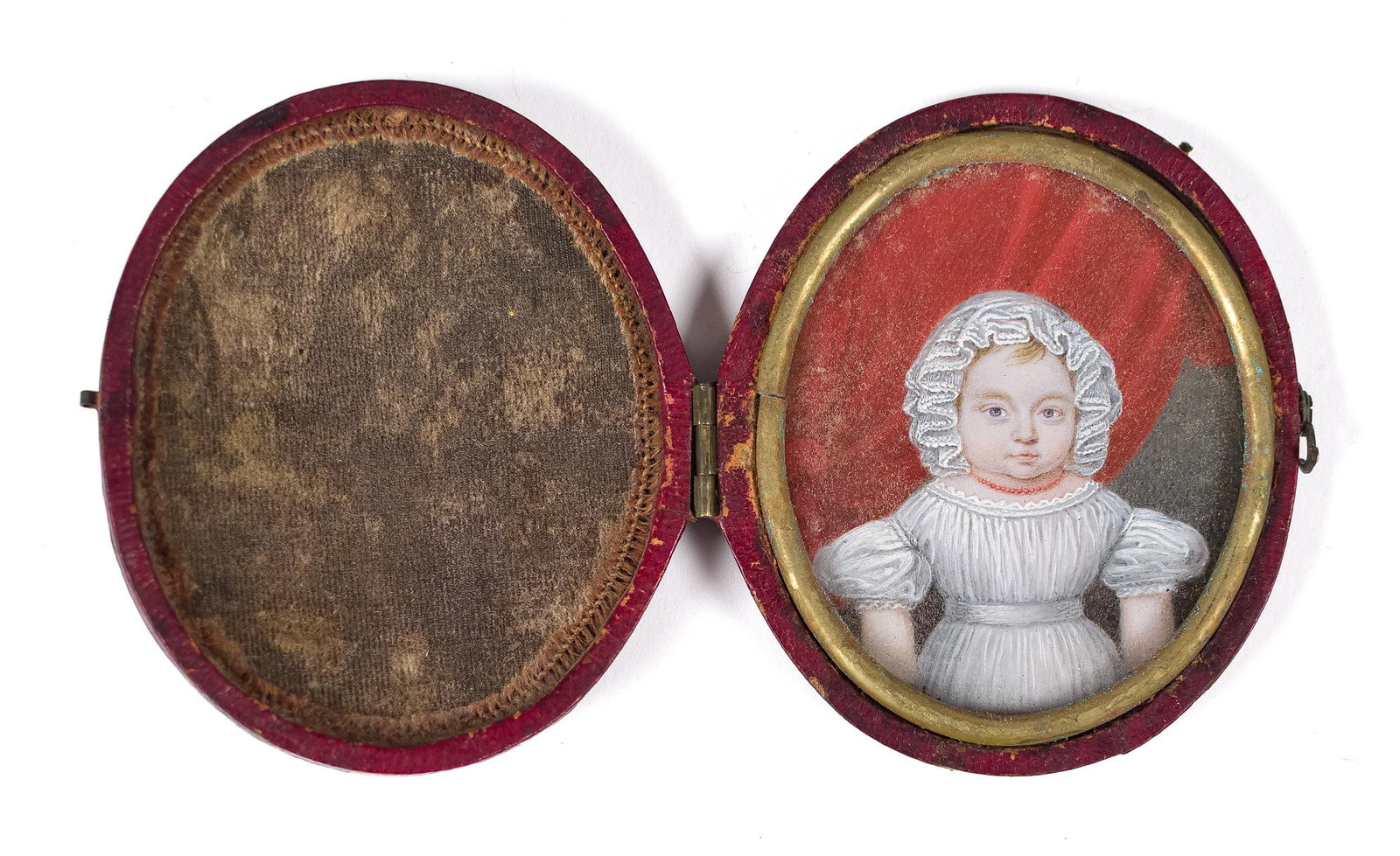 EARLY 19TH C. MINIATURE PAINTING, CHILD IN WHITE.: A very well painted early 19th C. miniature painting, a young child in a white bonnet and matching dress, wearing a red coral necklace, framed in an early oval red leather case, 2.75” x