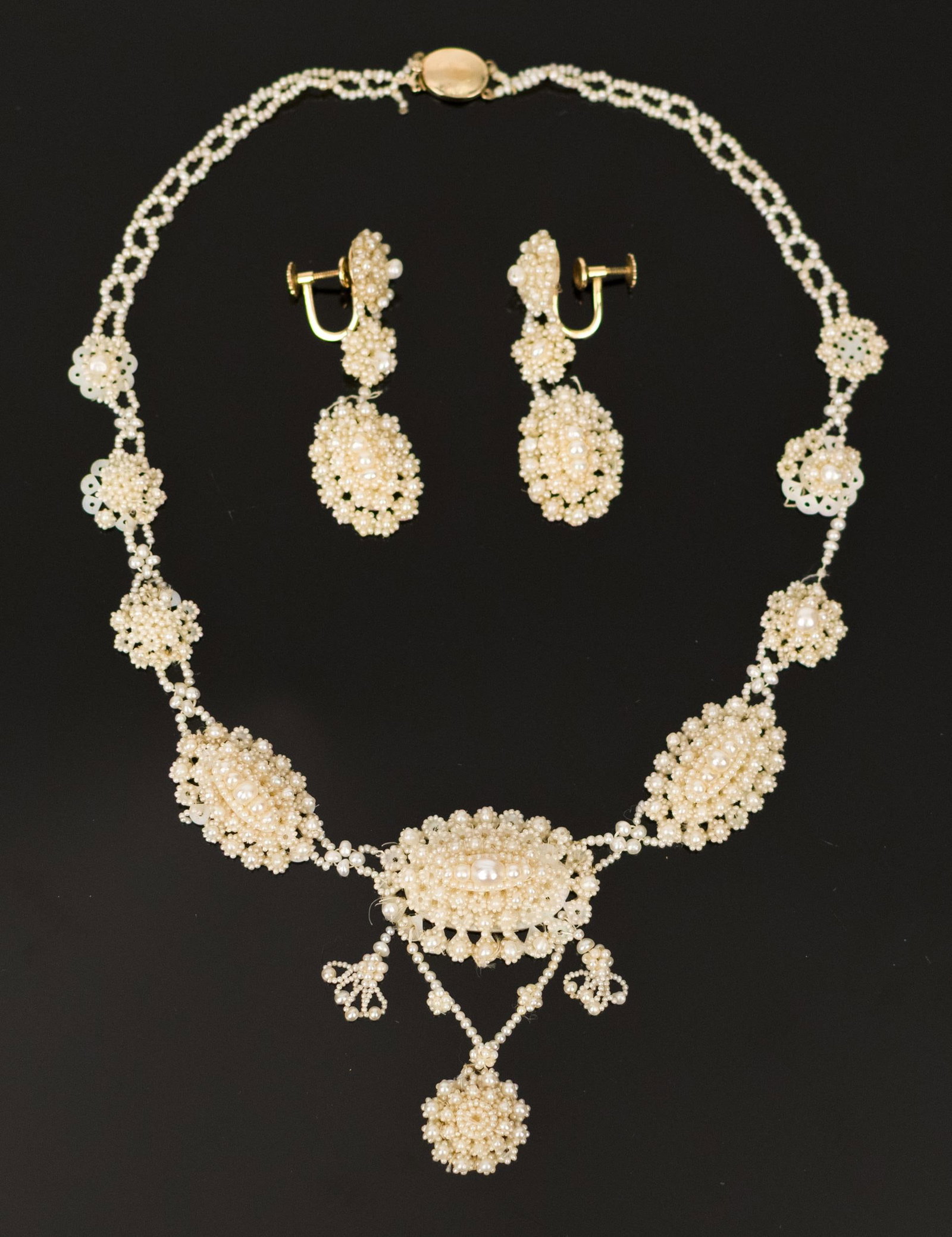 VICTORIAN 14K GOLD SEED PEARL NECKLACE & EARRINGS.: Victorian, woven seed pearl necklace (on mother-of-pearl), with 14k yellow gold (stamped) 17 inches long and dangle screwback earrings with 14k yellow gold (stamped), findings, 2 inches long.
