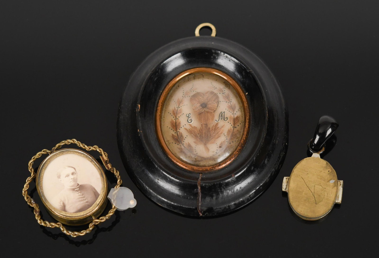 VICTORIAN HAIRWORK & PORTRAIT MEMORABILIA.: Victorian hairwork and portrait memorabilia:black framed hair art, Memento Mori, EM, 5 x 4 3/8”, cracked frame, artwork in good condition, glass soiled;base metal, locket w/ carved jet bail,