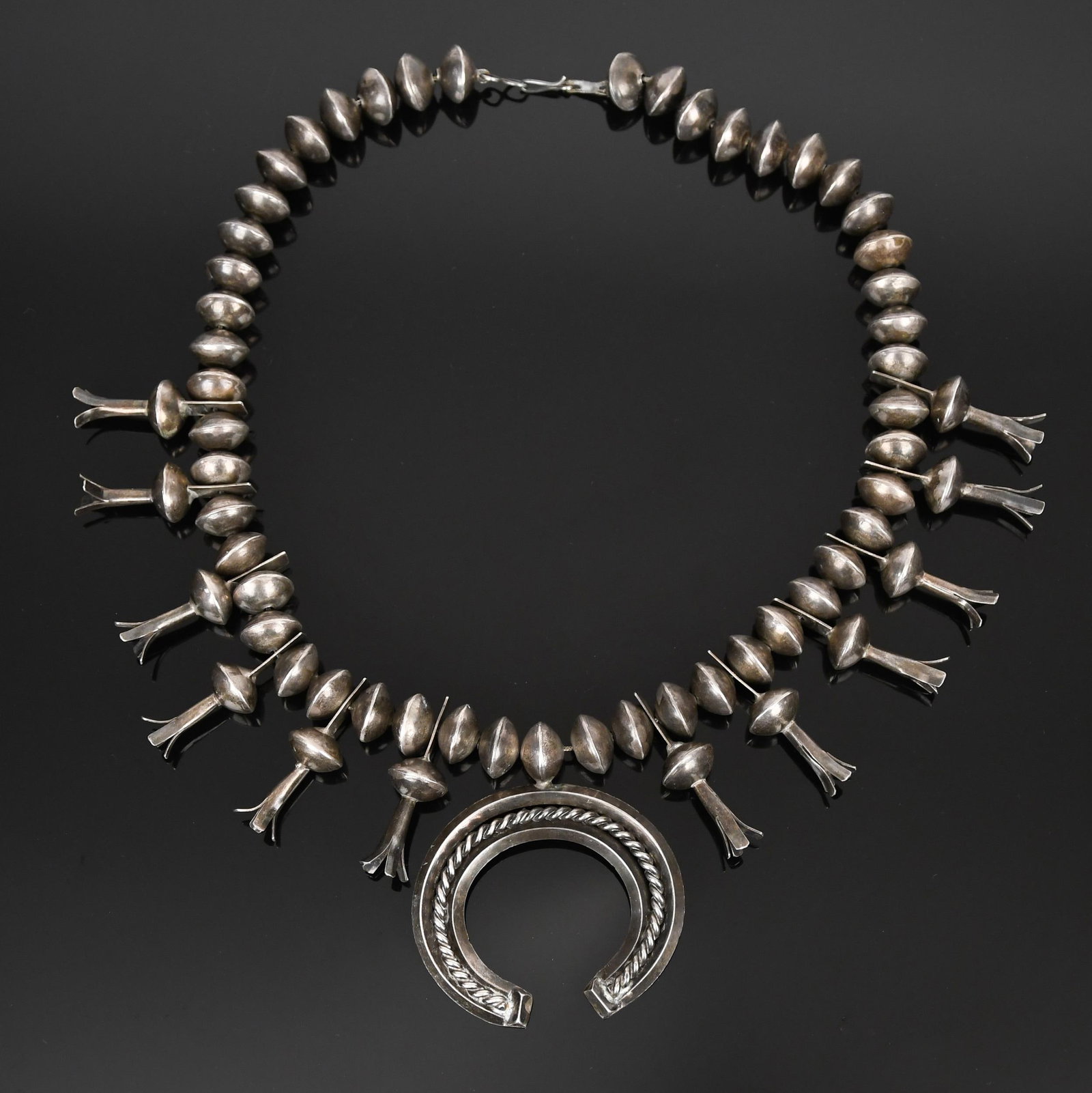 VINTAGE STERLING SILVER SQUASH BLOSSOM NECKLACE.: A vintage, handmade, Native American, sterling silver (tested), squash blossom necklace, 17mm dia. Navajo pearls (beads), naja is 2 3/4 inches wide, 25 3/4 inches long, 7.65 oz t..