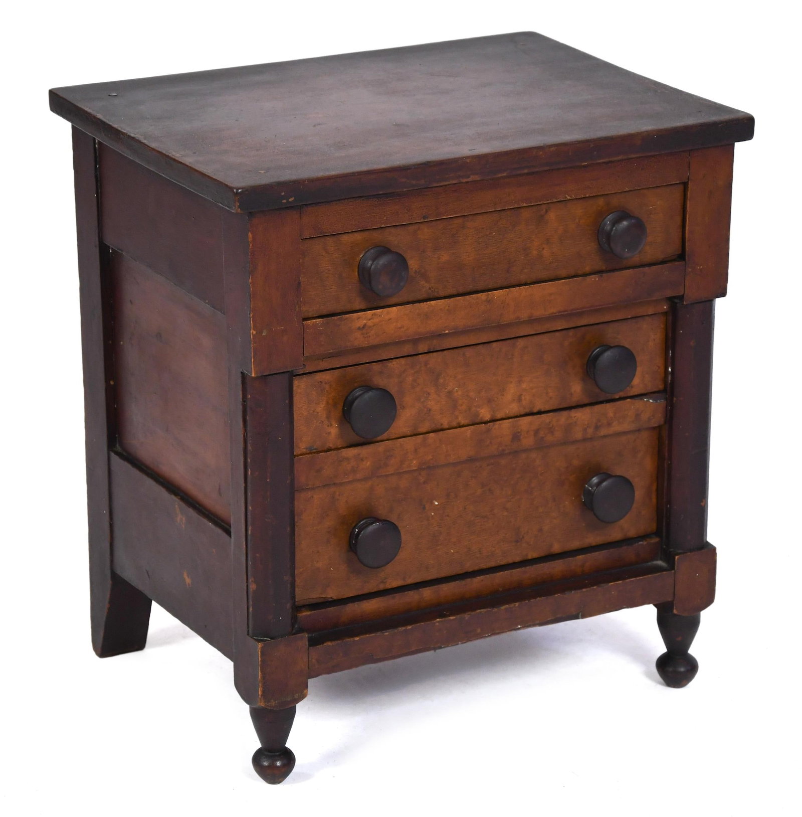 19TH C. NY MINIATURE/CHILDS SIZE CHEST.: A ca. 1840 miniature or child’s size Sheraton transitional cherry chest with three drawers veneered with birdseye maple fronts, flanked by shaped columns, on turned feet. 18.25”H x