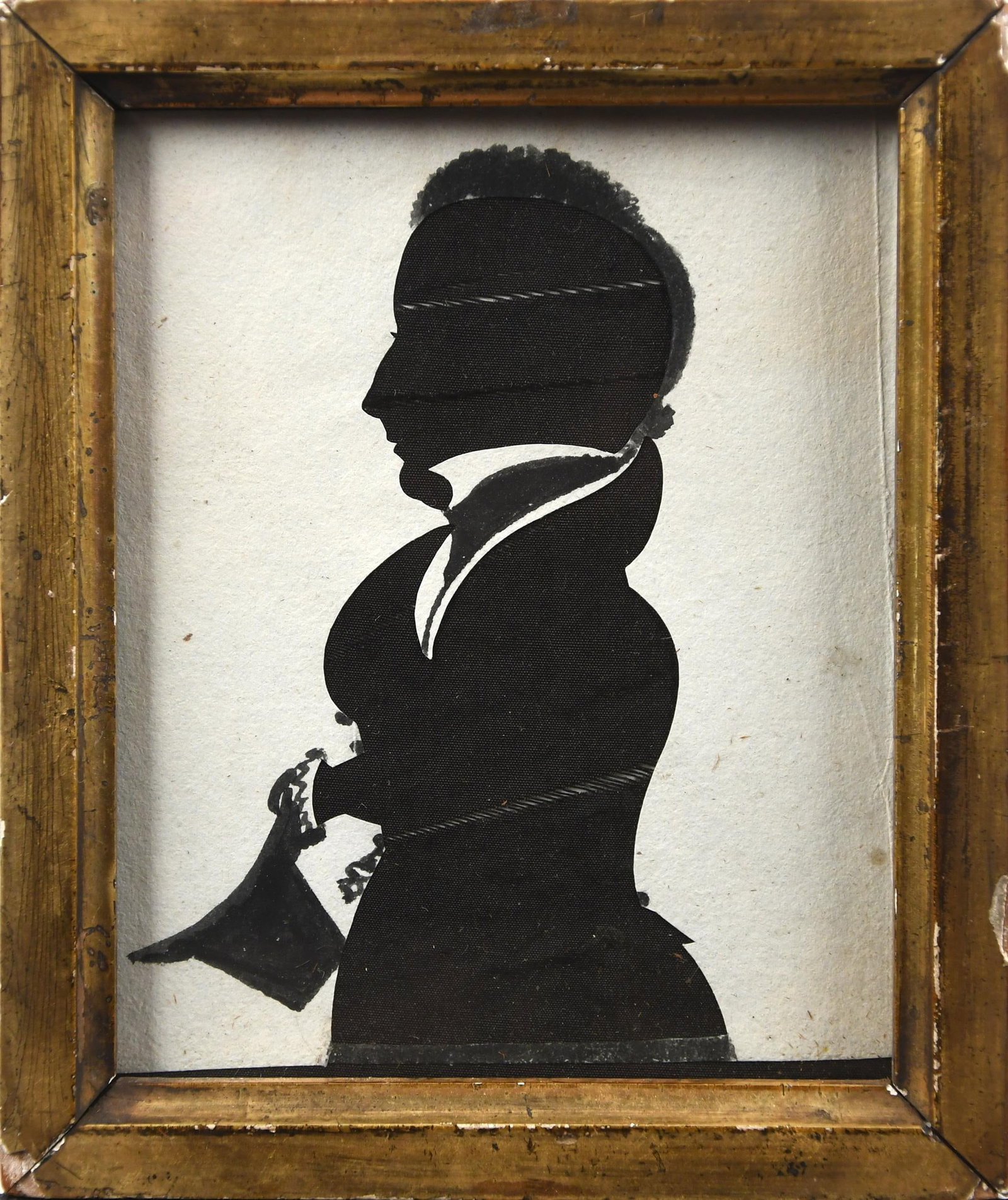 19TH C. SILHOUETTE ATTRIB TO EZRA WOOD.: An early 19th C. hollow cut silhouette, profile of a gentleman holding a hat with applied ink decoration to the outer edges. Image 4” x 3.5”, Frame 5.5” x 4.5”.