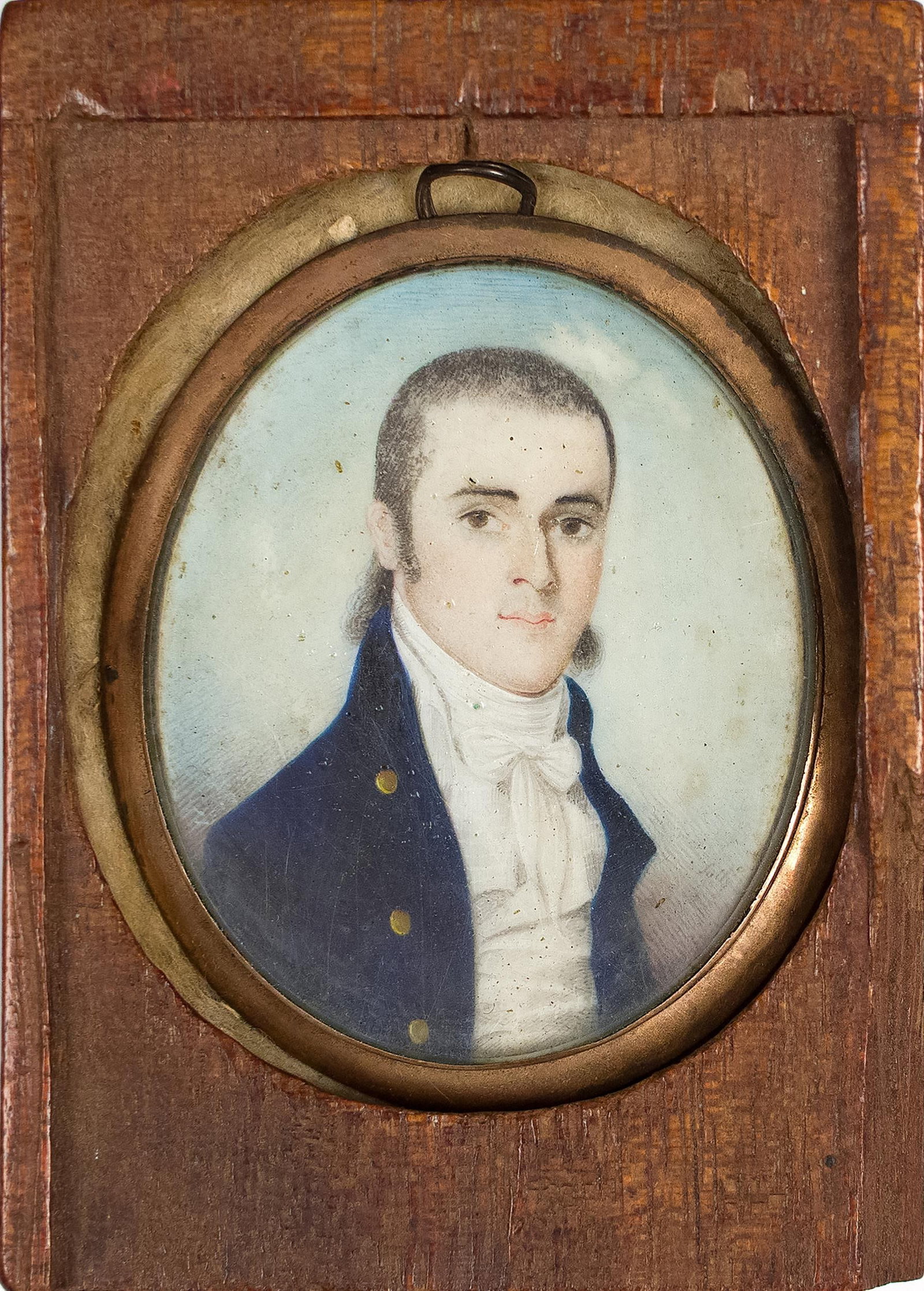 FEDERALIST ERA MINIATURE PAINTING, ATTRIB. HANCOCK.: A ca. 1800 miniature painting of a man in blue coat with gold buttons, possibly a sea captain, attributed to Nathaniel Hancock, in a gold frame and wood case. Image 2” x 1.75”, Case 3.25&#