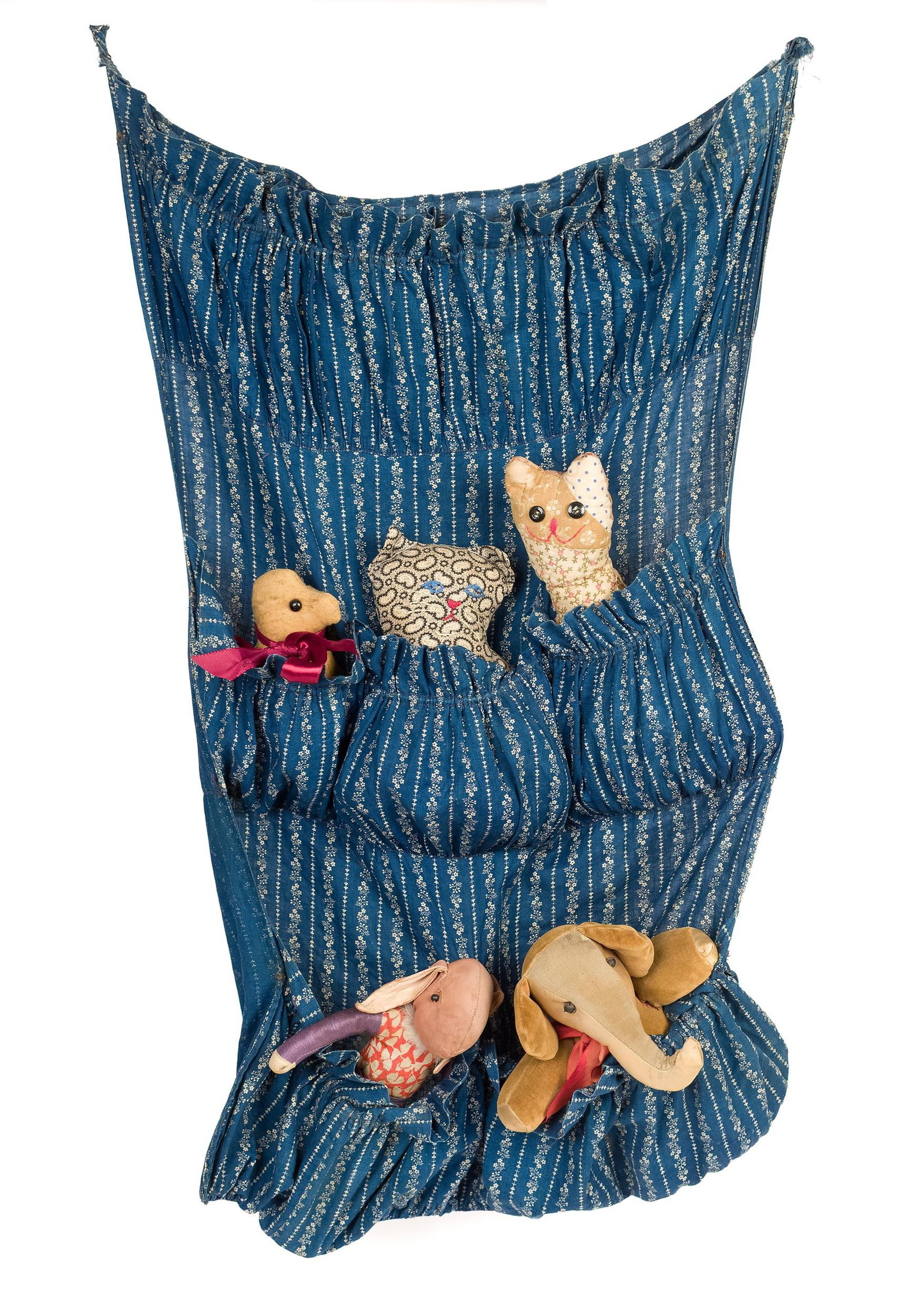 VINTAGE HANGING CALICO FABRIC POCKET WITH ANIMALS.: A vintage sewn blue calico wall hanging fabric with five pockets which contain five vintage/antique stuffed toy animals. Hall hanging 29”H x 16”W. Provenance: from the lifelong, curated co