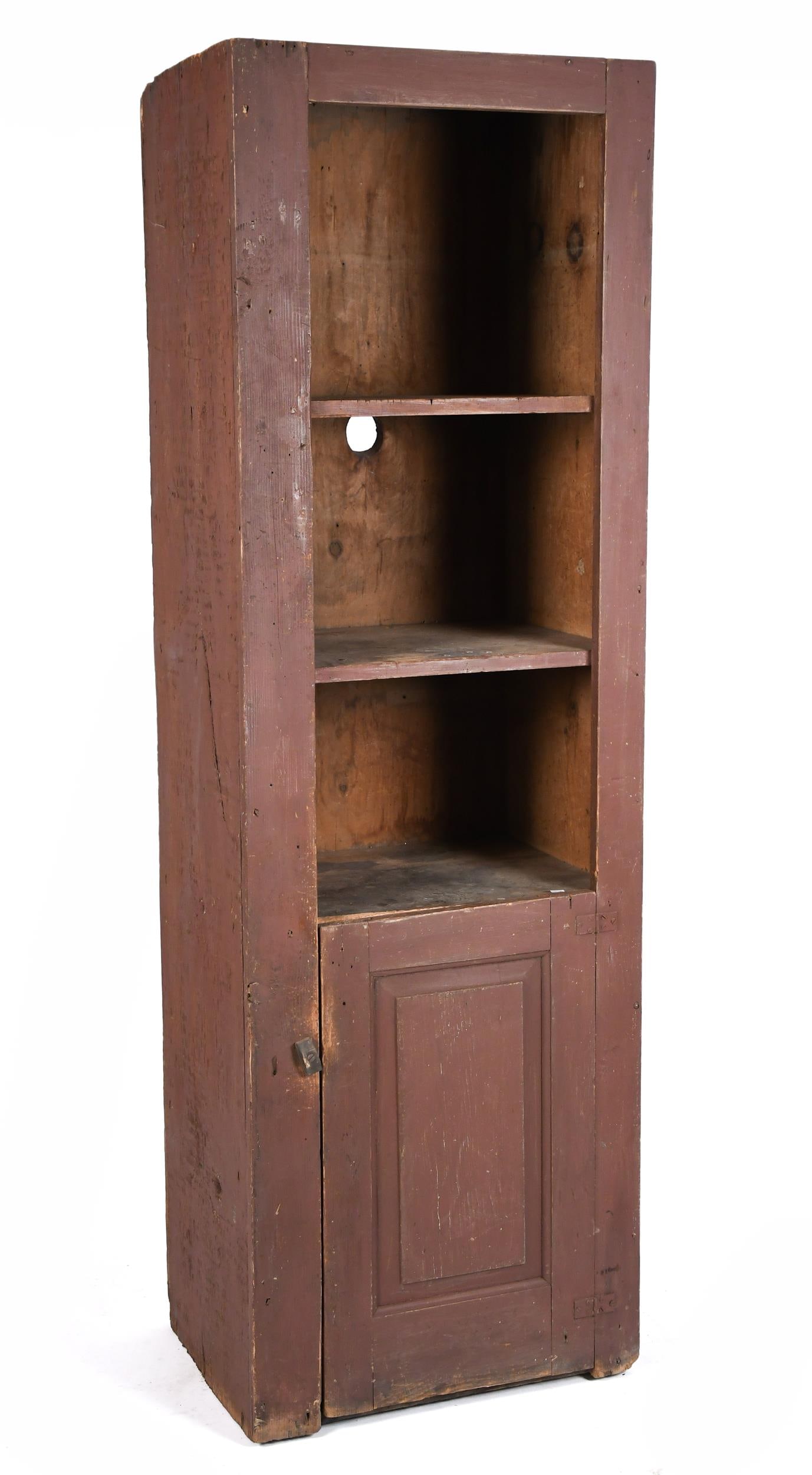 19TH C. RED PAINTED CHIMNEY CUPBOARD.: A 19th C. American primitive country red painted chimney cupboard with an open top over a paneled door. 74.5”H x 23.75”W x 18”D.