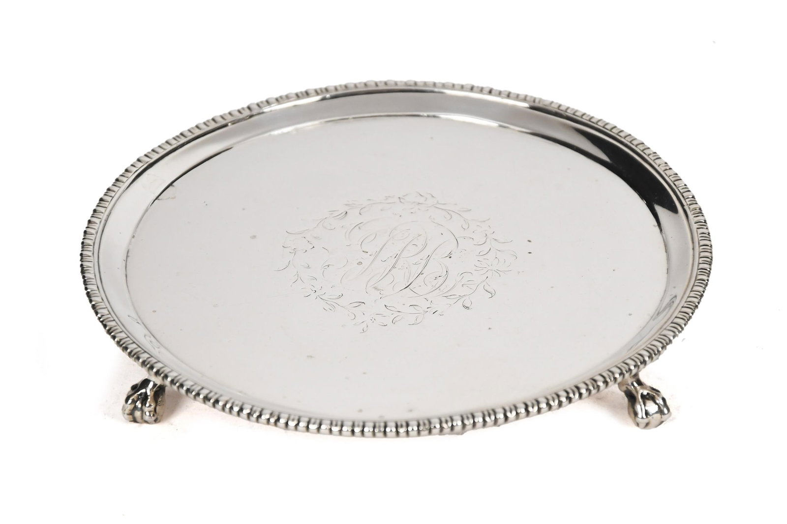 VINTAGE ENGLISH TRIFID STERLING SALVER.: An early 20th C. English sterling salver with gadrooned edge and claw and ball trifid feet. Monogrammed with floral wreath and crown, lion, and RR cartouches. 6.50 oz t. 1”H x 5.75” dia.