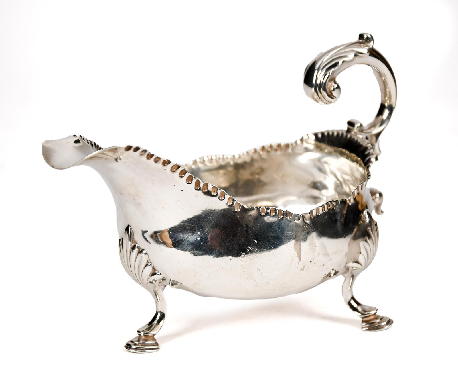 ANTIQUE ENGLISH STERLING GRAVY/SAUCE BOAT.: A late 19th/early 20th C. English sterling silver gravy/sauce boat with gadrooned rim and acanthus decoration on thumb rest and foot joints, terminating in trifid legs on horseshoe feet. Lion and