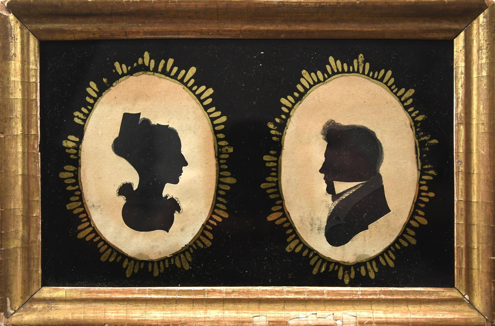 19TH C. AMERICAN SCHOOL DOUBLE SILHOUETTE.: Early 19th C. Hollow cut and hand colored double silhouette man and woman with the original eglomise in a period frame, 6” x 9” overall.