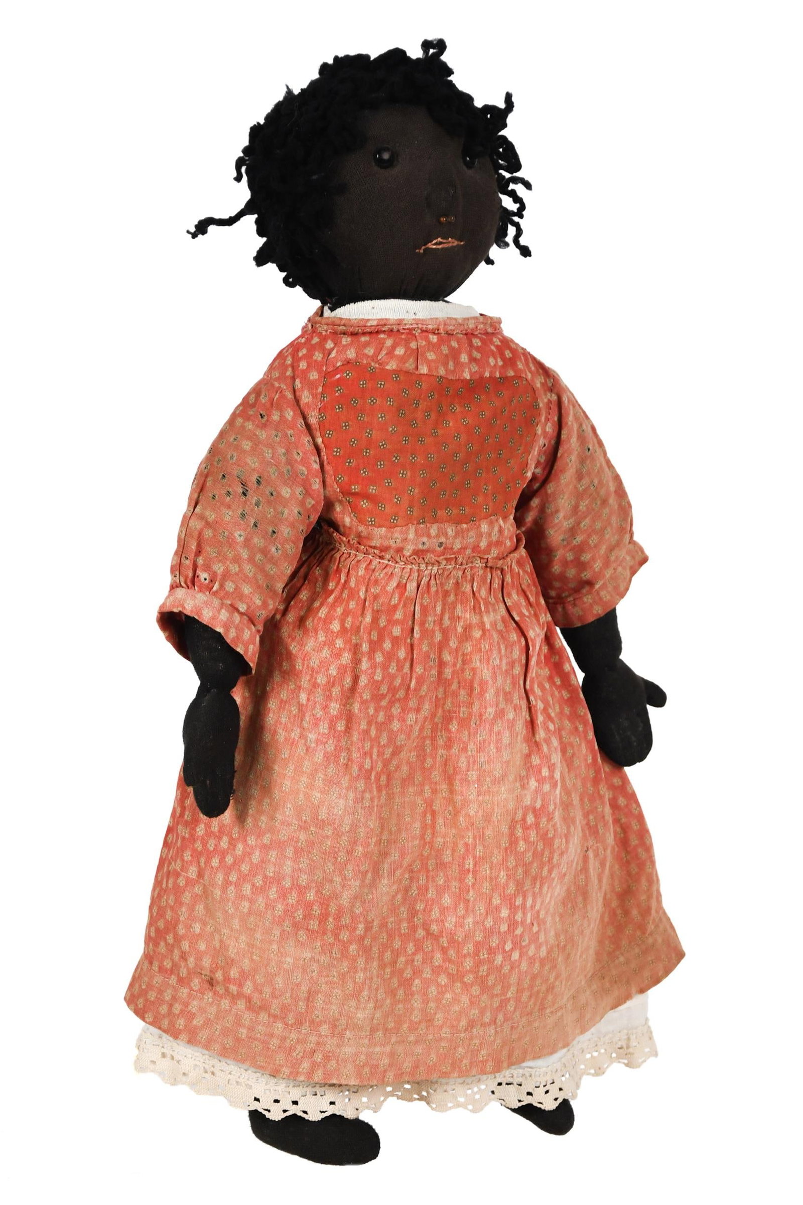 19TH C. STOCKINETTE CLOTH DOLL.: A ca. 1890 stockinette cloth doll with expressive stitched and glass eyed and nostrilled face, woolen hair, and original clothing. 17.5”H. Provenance: from the lifelong, curated collection of