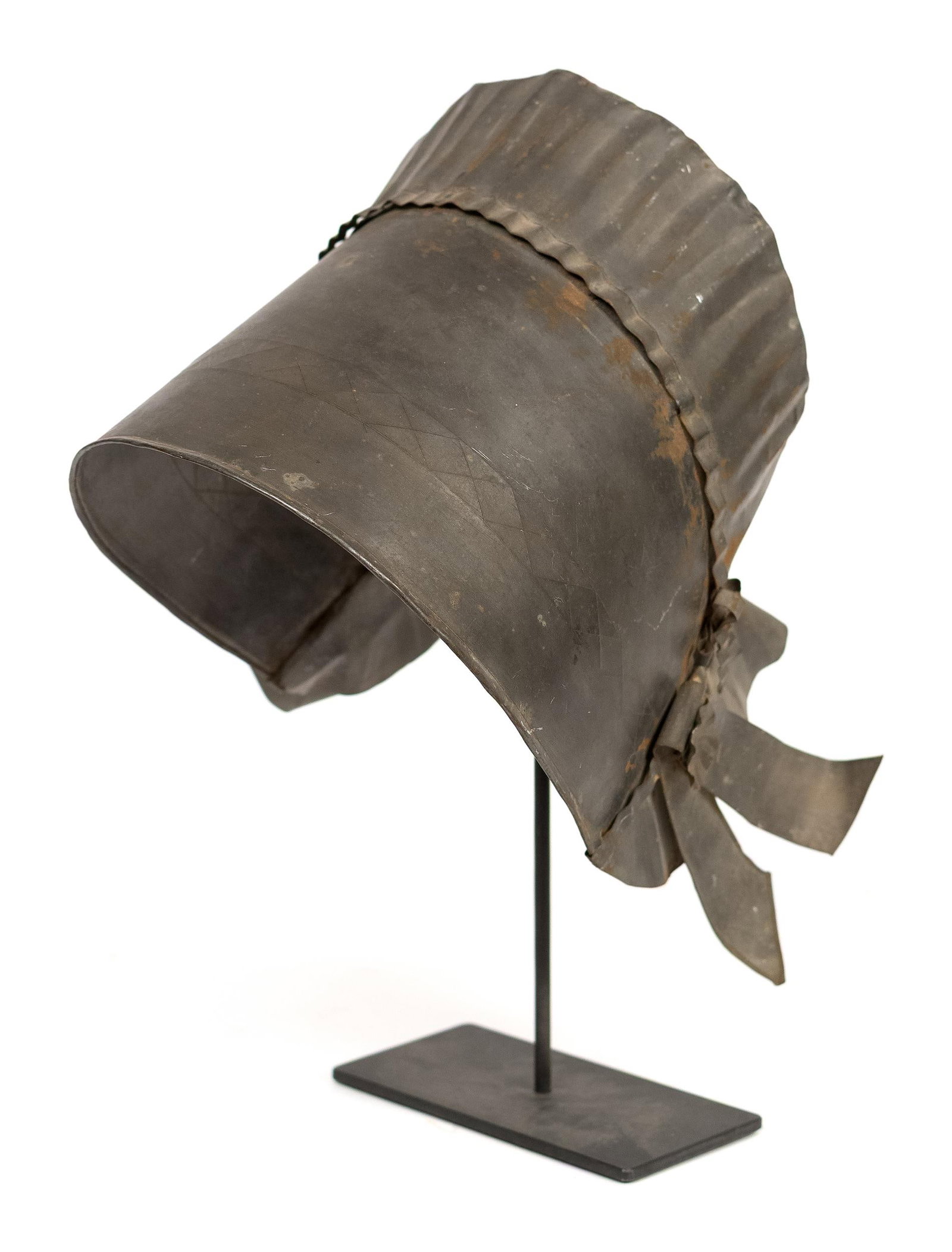 ANTIQUE METAL BONNET SCULPTURE.: A 19th C. unconventional Tenth Anniversary tin bonnet, woman’s bonnet sculpture on stand. 15”H x 11.5”W x 11”D. Provenance: from the lifelong, curated collection of Kathy Schoe