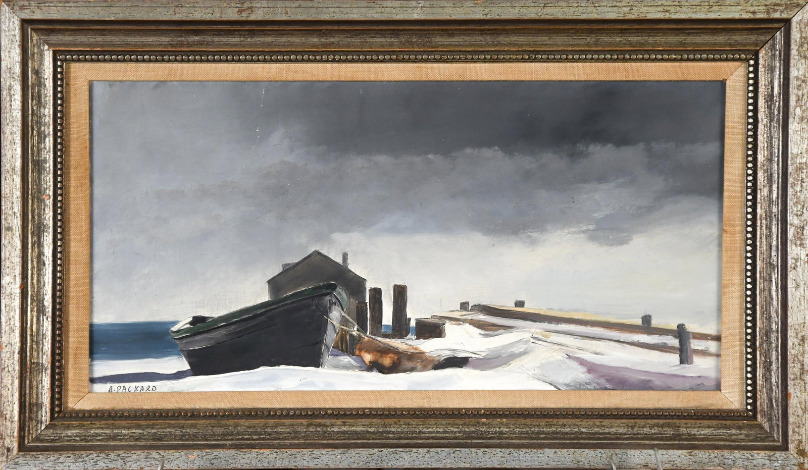 ANNE PACKARD, OIL ON MASONITE, SNOWY WHARF.: Anne Packard (American, b. 1933), Provincetown, Massachusetts, oil on masonite, winter waterfront with a beached dory, shed, and pilings under a heavy gray sky, signed lower left “A.