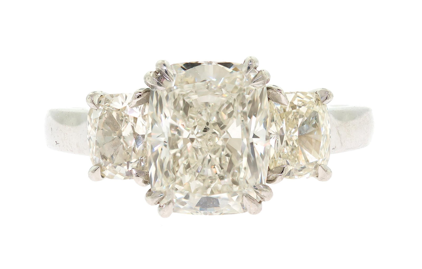 PLATINUM 3.85 CT. RADIANT & CUSHION CUT DIAMOND RING.: A platinum (stamped), three-stone ring, set with an approx. 3.85 ct., radiant cut, natural diamond of K-L color and I1 clarity, measuring, 10.22 x 8.13 x 5.51mm deep, flanked by approx. 1.50 ct. tw.,