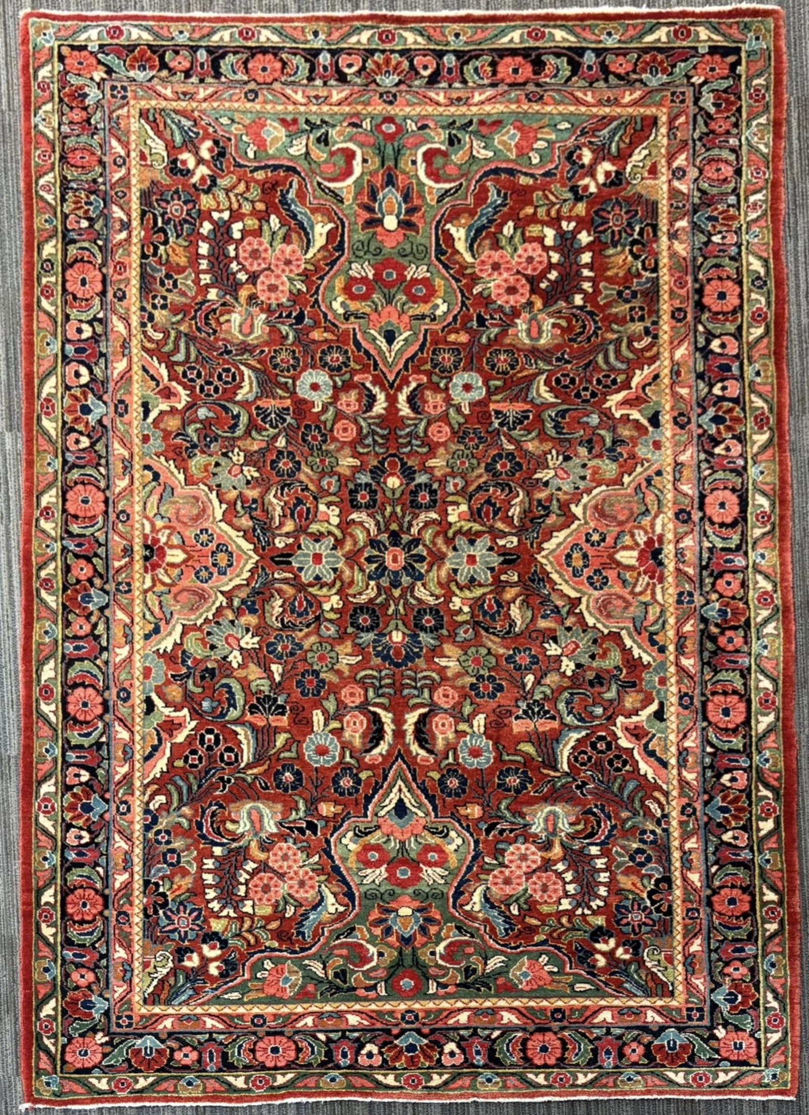ANTIQUE ORIENTAL SAROUK SCATTER RUG.: An antique Persian Sarouk scatter rug, with a rich red field with an elaborate floral design of palmettes, flowering sprays, scrolling vines, and stylized leaves in navy, ivory, rose, pale blue, green