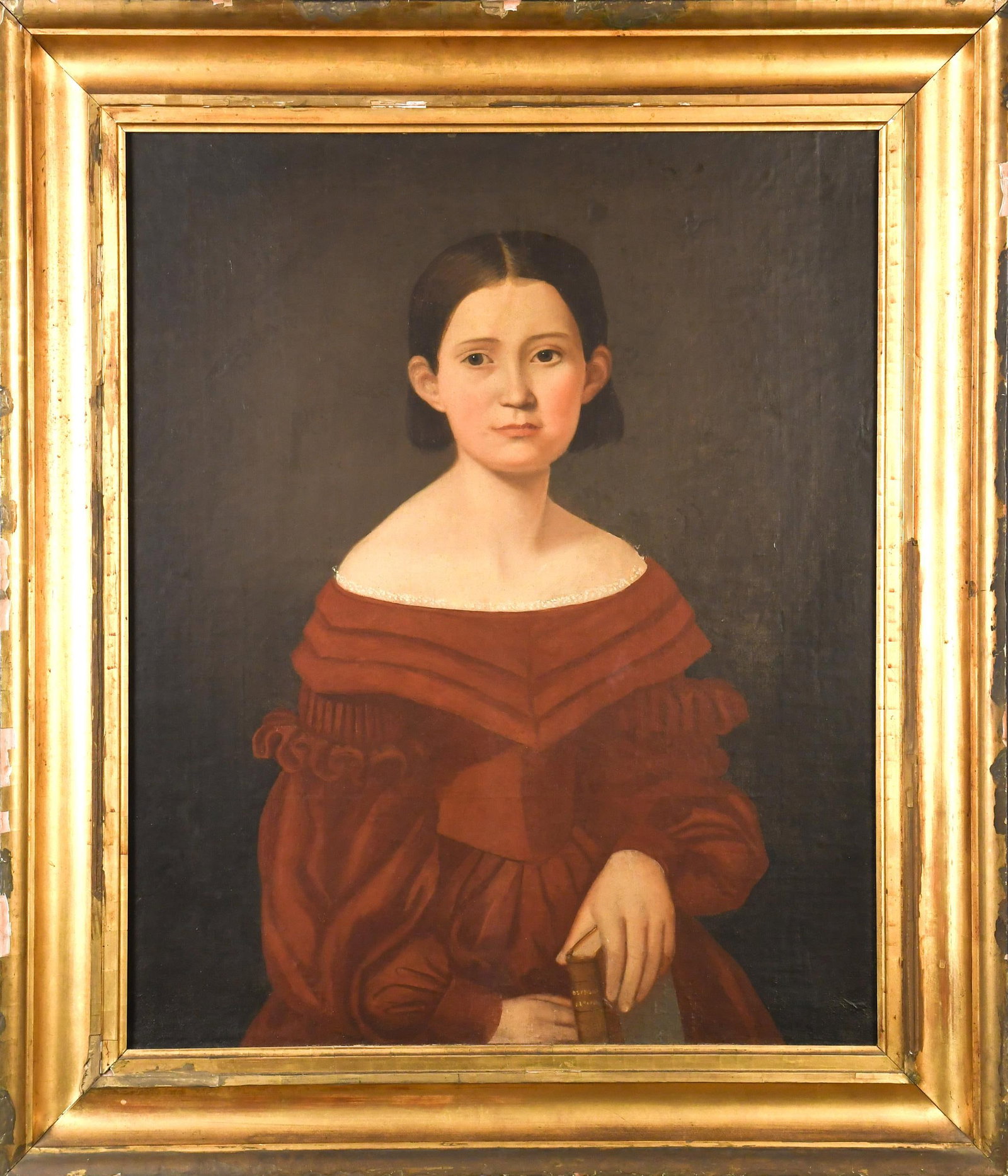 19TH C. OIL, PORTRAIT OF GIRL IN RED DRESS.: A 19th C. oil on board, portrait of a girl with short brown hair in a red dress, holding a book in her lap. Unsigned. Image 29.5” x 24”, frame 37” x 32”.