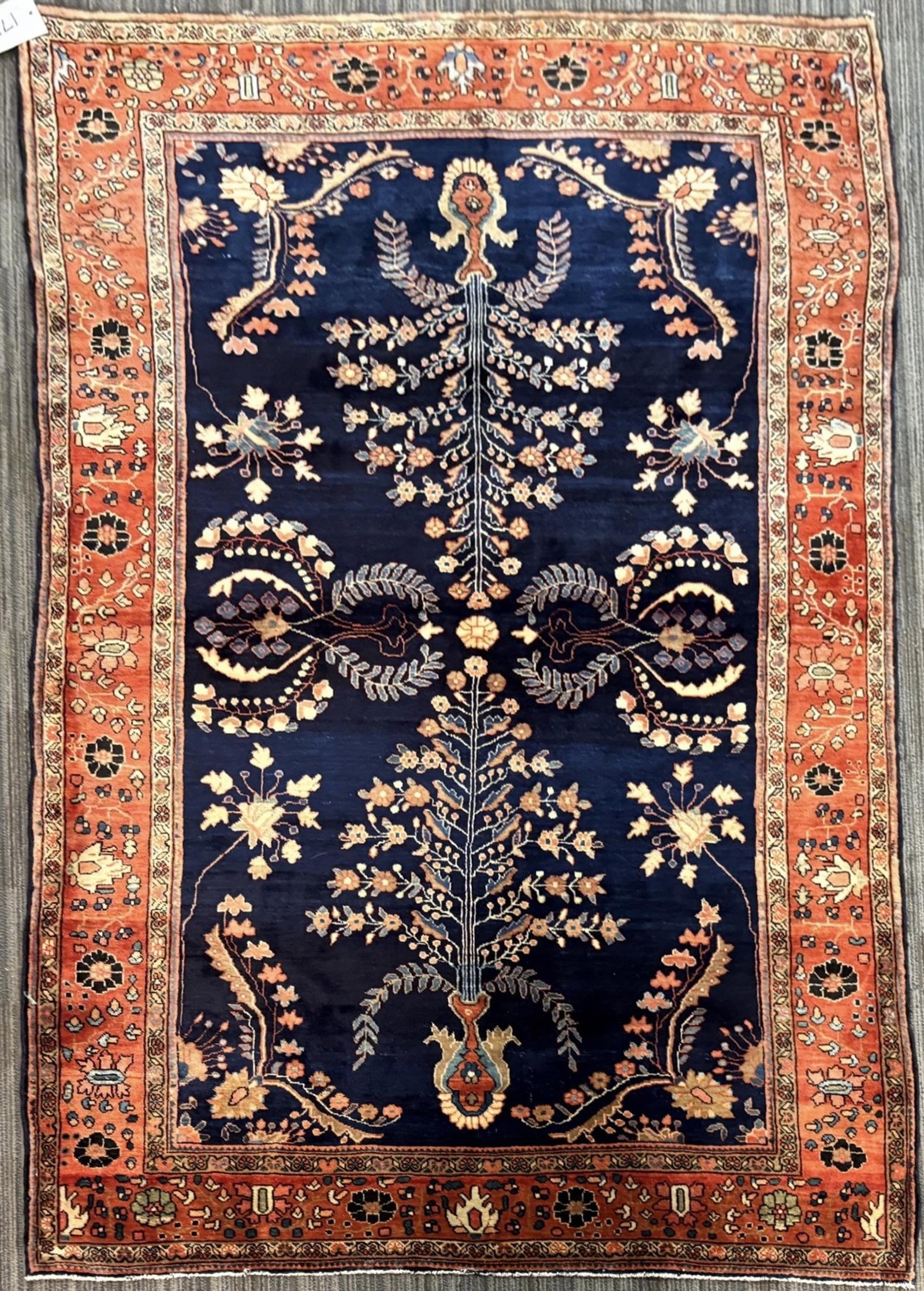 ANTIQUE PERSIAN SCATTER RUG.: Antique Persian scatter rug with a deep navy blue field centered by a vertically arranged flowering tree-of-life designs, stylized floral sprays, palmettes, and scrolling branches in ivory, salmon, ru