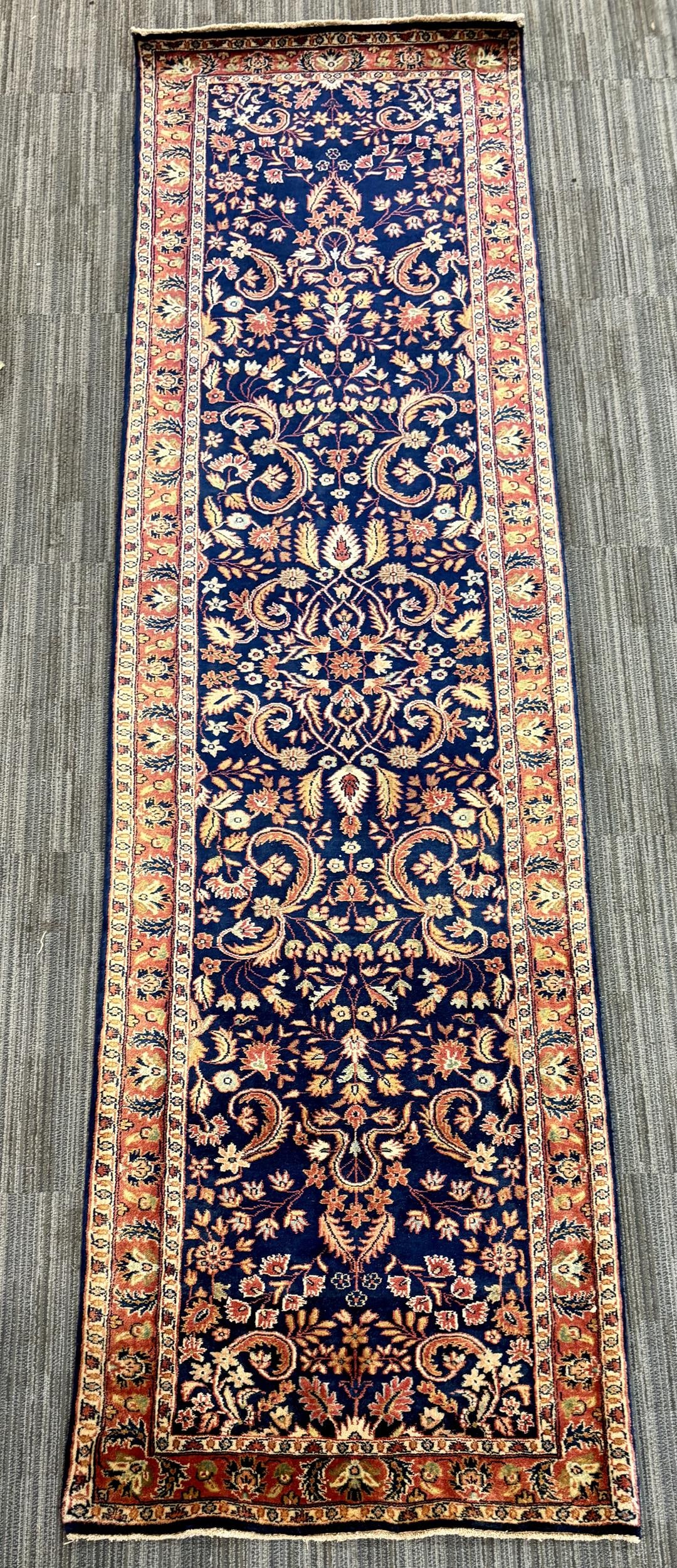 VINTAGE ORIENTAL SAROUK RUNNER.: A vintage Oriental Sarouk runner, with a deep navy field decorated with an elegant symmetrical floral design of scrolling vines, palmettes, rosettes, and leafy sprays in ivory, salmon, rust, pale blue